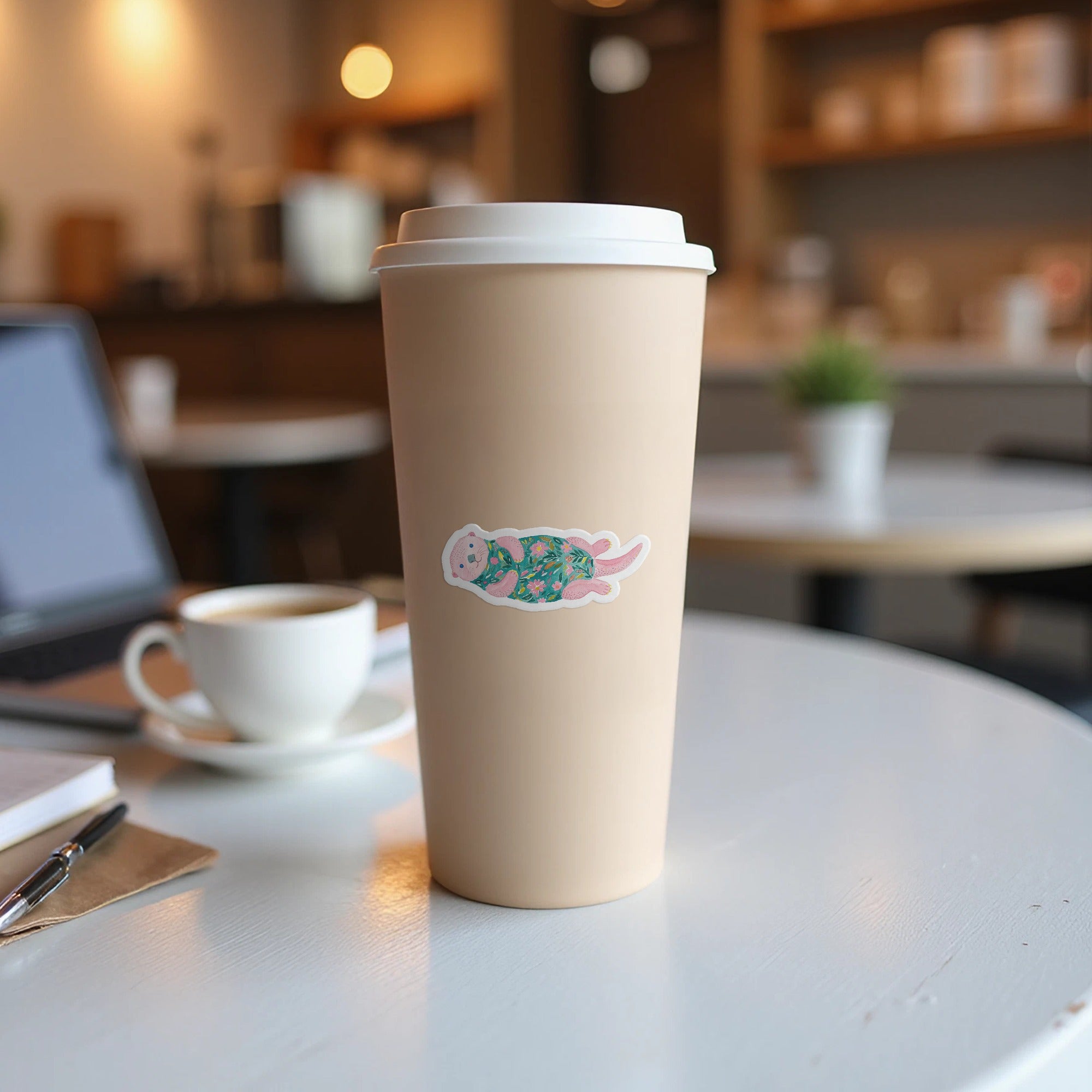 Sticker of a sloth wearing a floral sweater on a coffee cup.