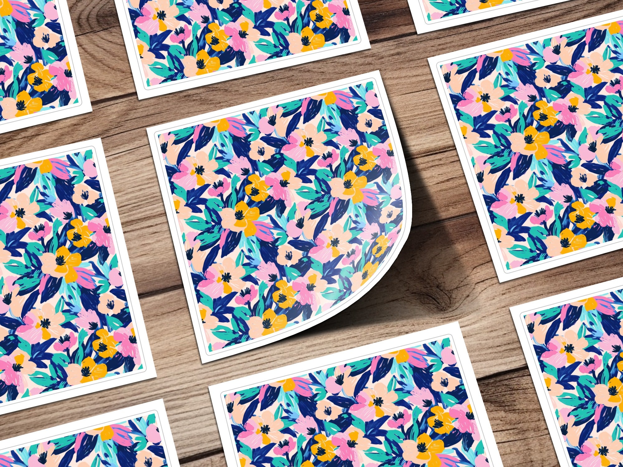 Floral patterned stickers with pink, yellow, and blue flowers on a wooden surface.