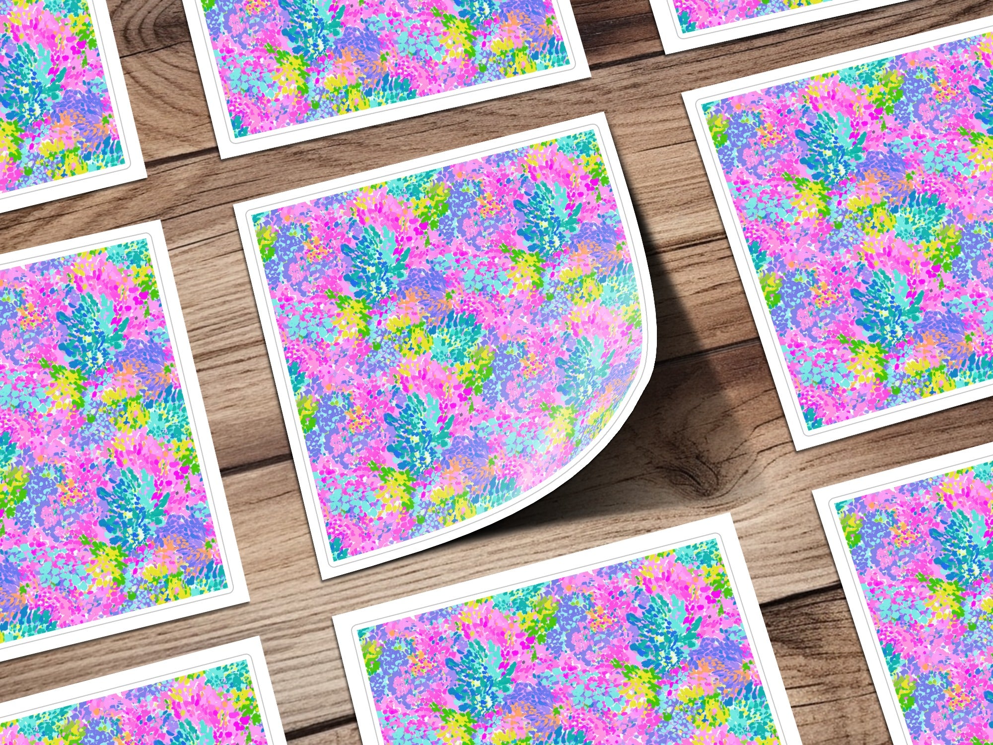 Colorful floral pattern on square cards scattered on a wooden surface.