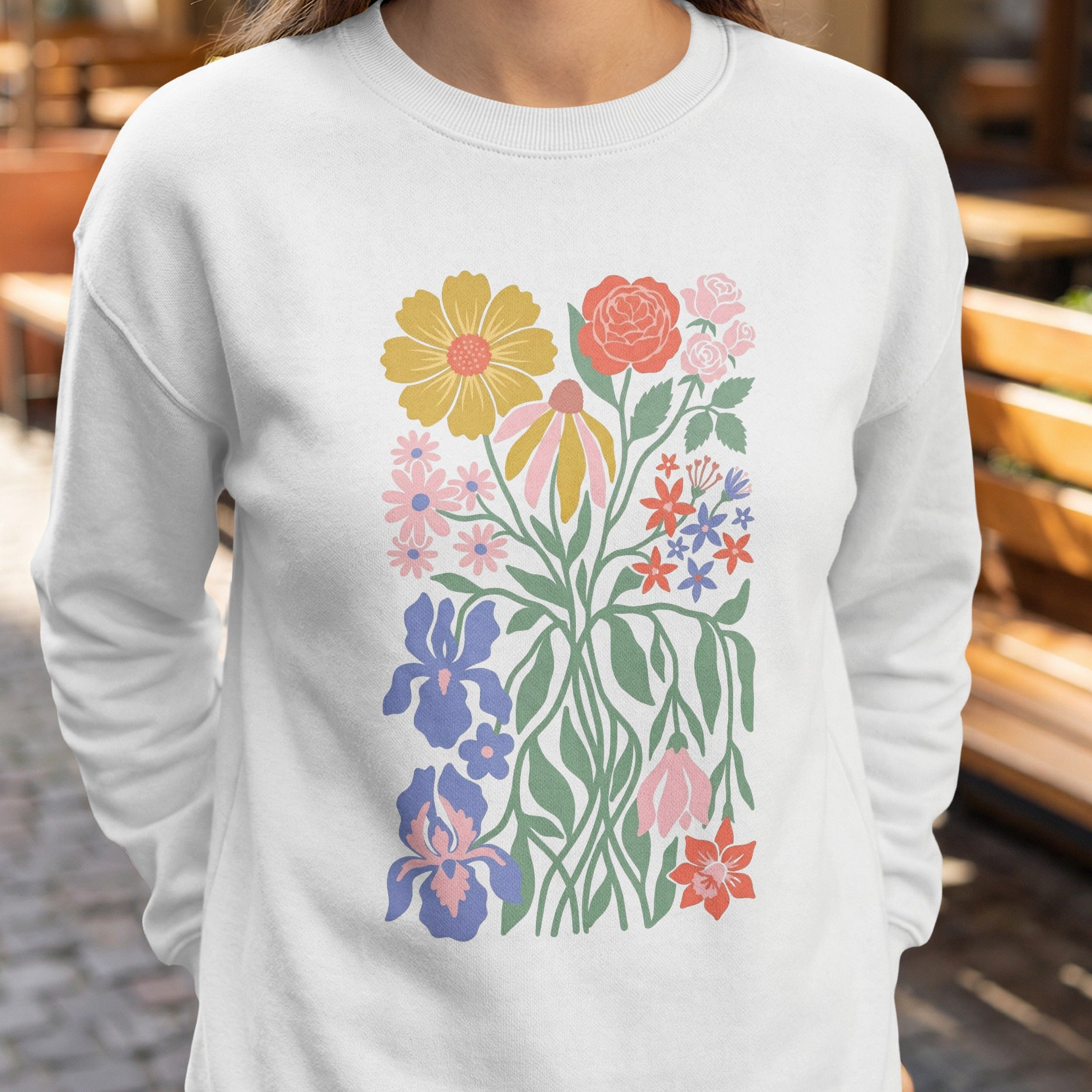 White sweatshirt with a colorful floral illustration.
