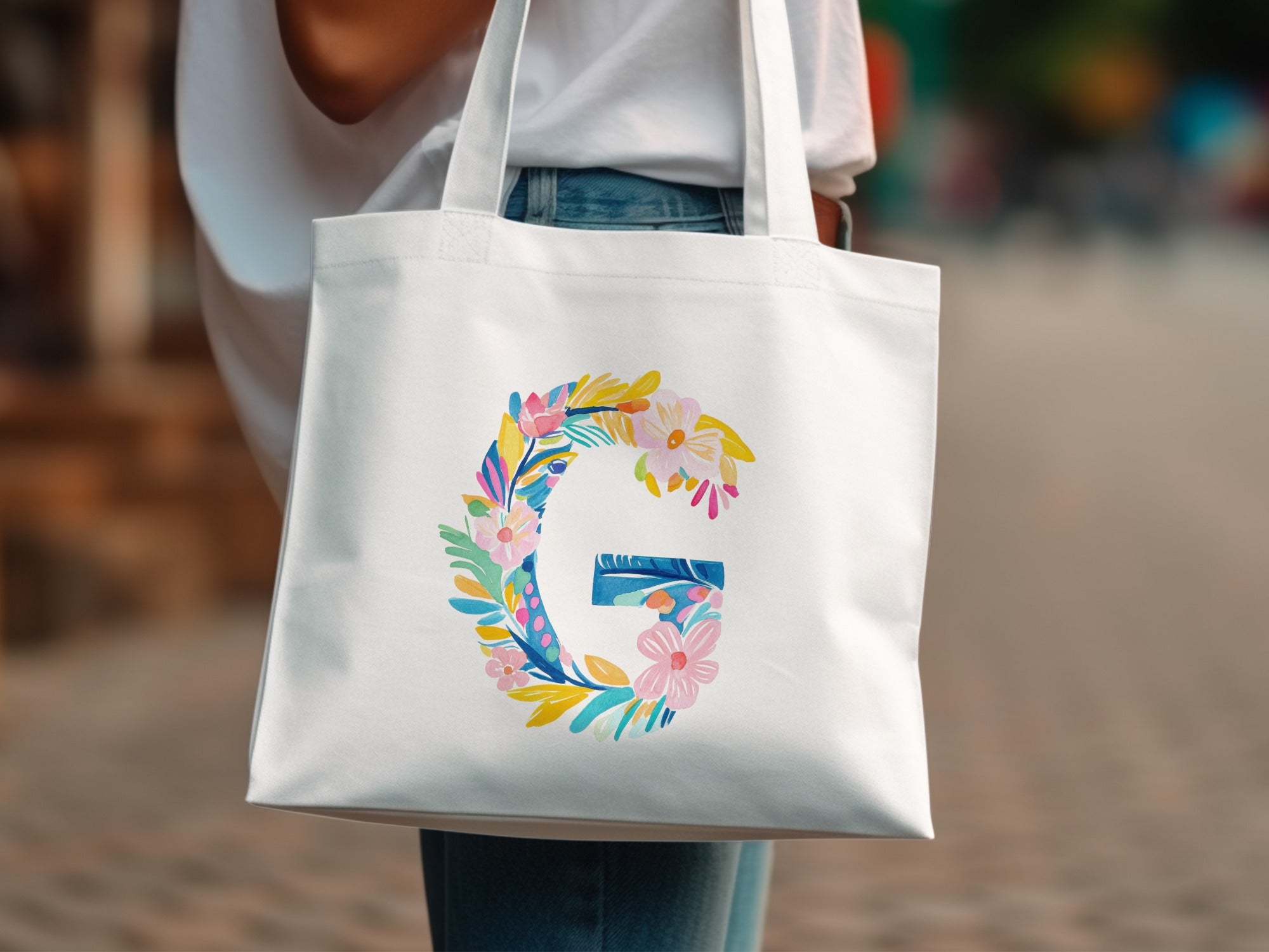 White tote bag with a floral letter G design.