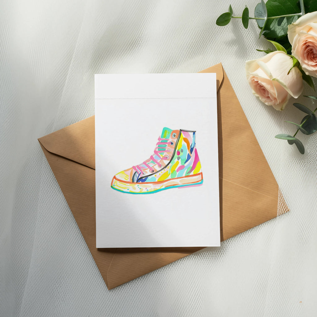 Colorful high-top sneaker illustration on a card placed on a brown envelope.