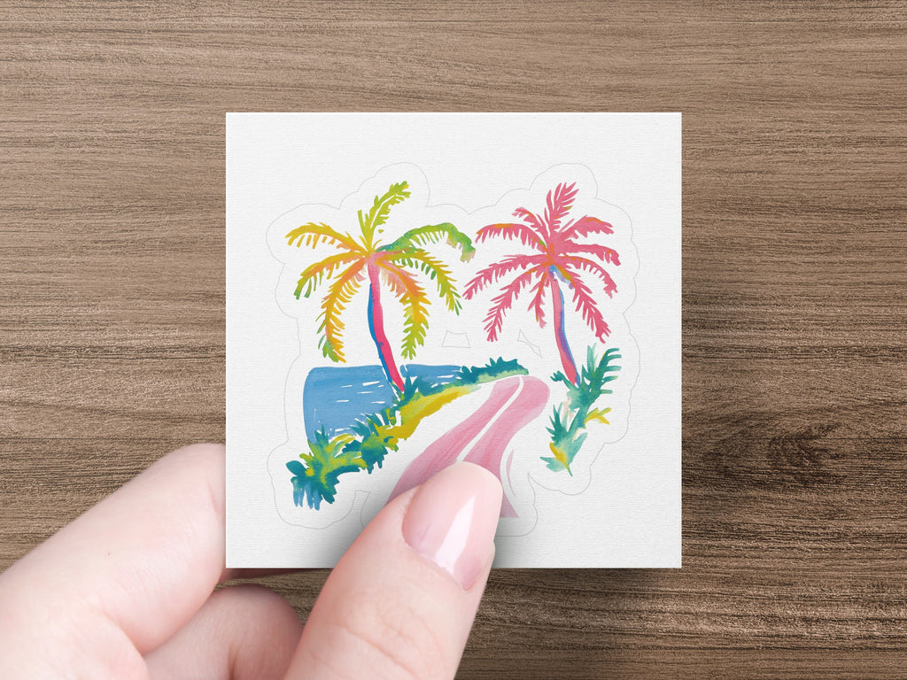 Hand holding a square sticker with a colorful tropical beach scene.