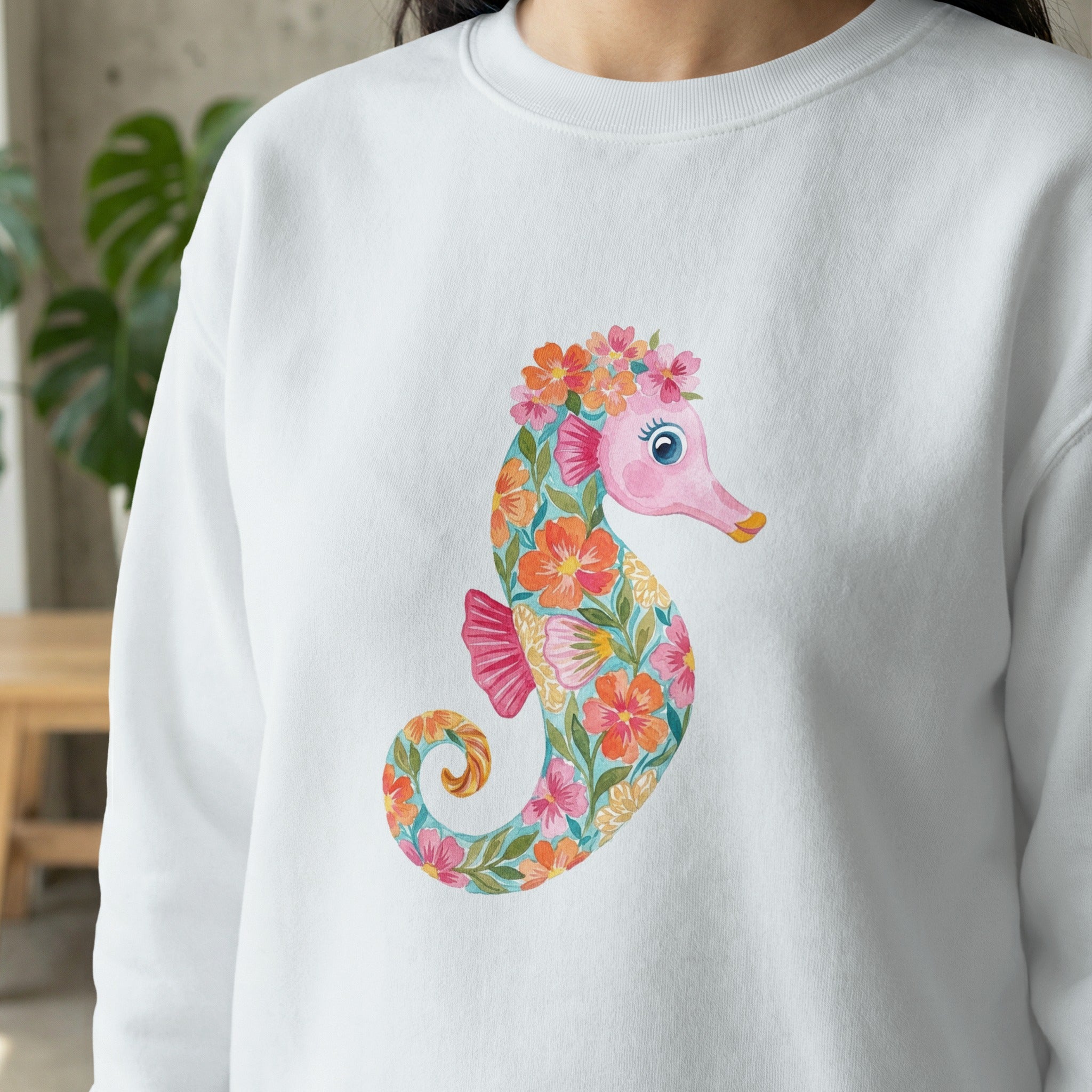 White sweatshirt with a floral seahorse illustration.