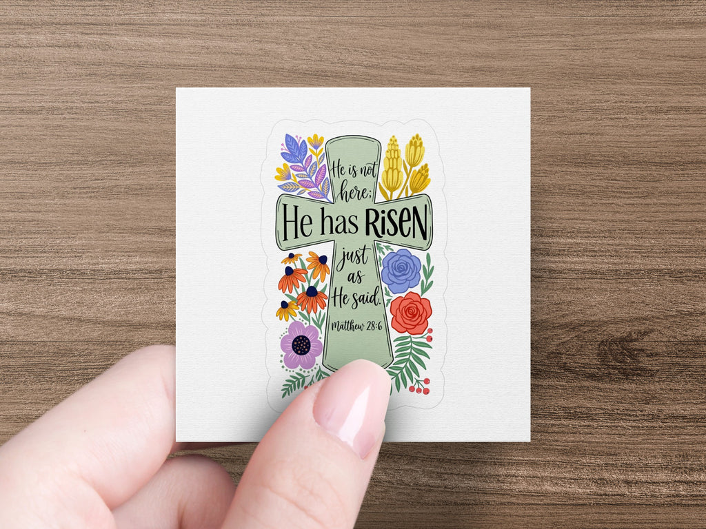 He has risen text on a cross design with floral accents.