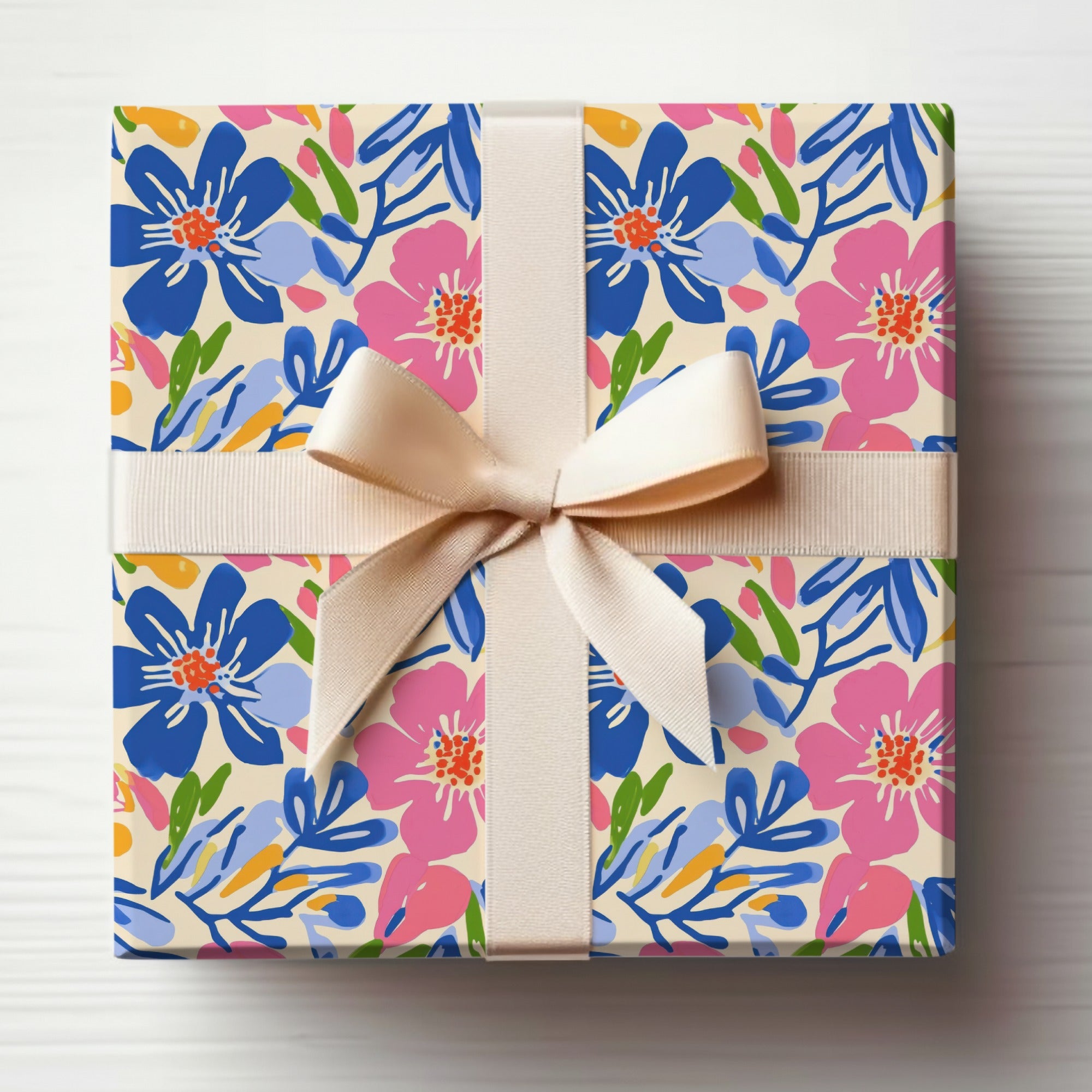 Gift box with cream ribbon and blue and pink floral pattern.