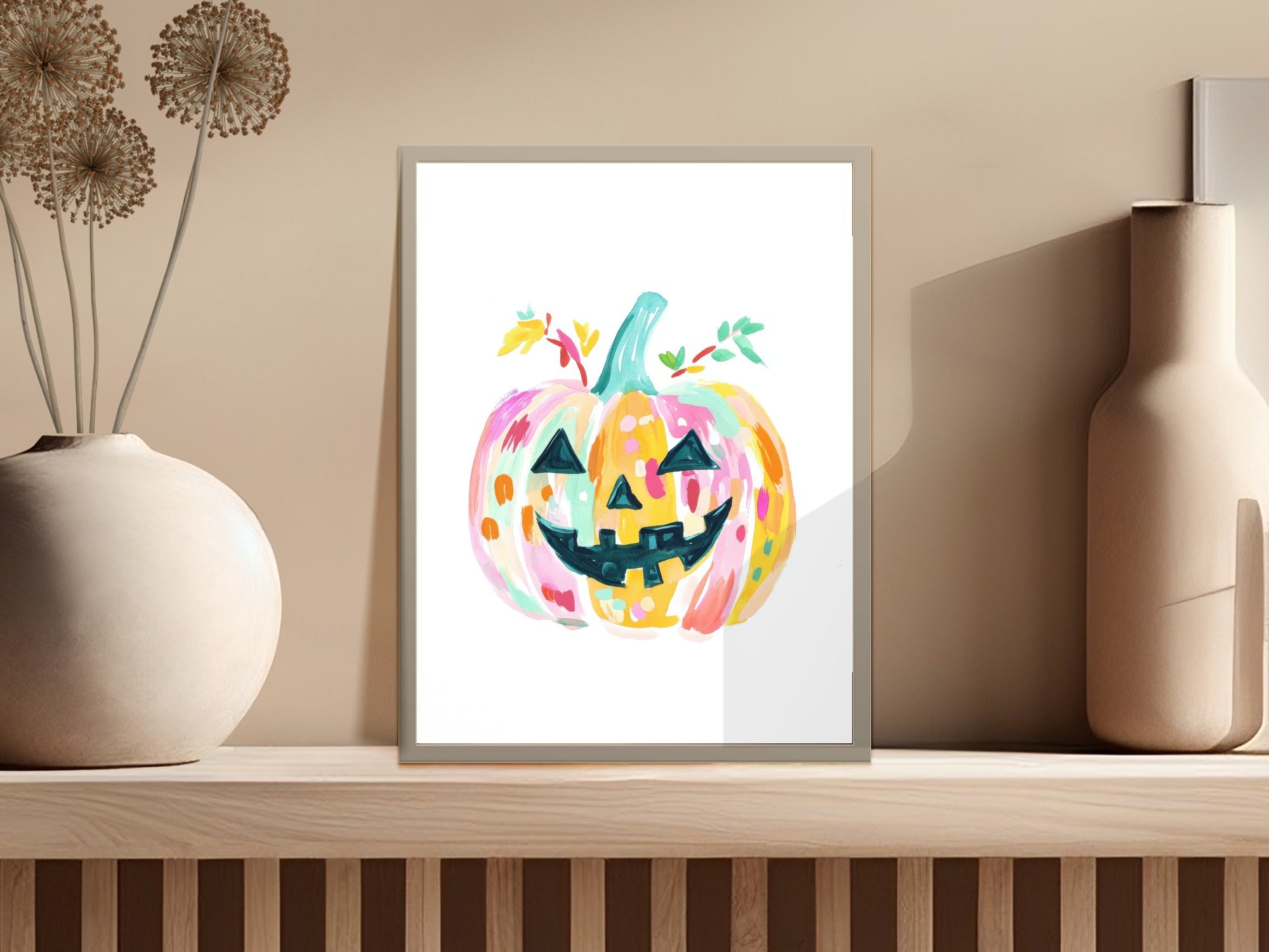 Colorful watercolor pumpkin art with leaves on a shelf.