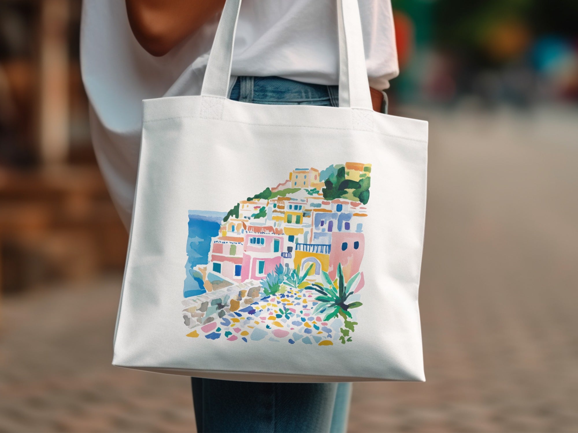 White tote bag with colorful watercolor painting of a coastal Italian village.