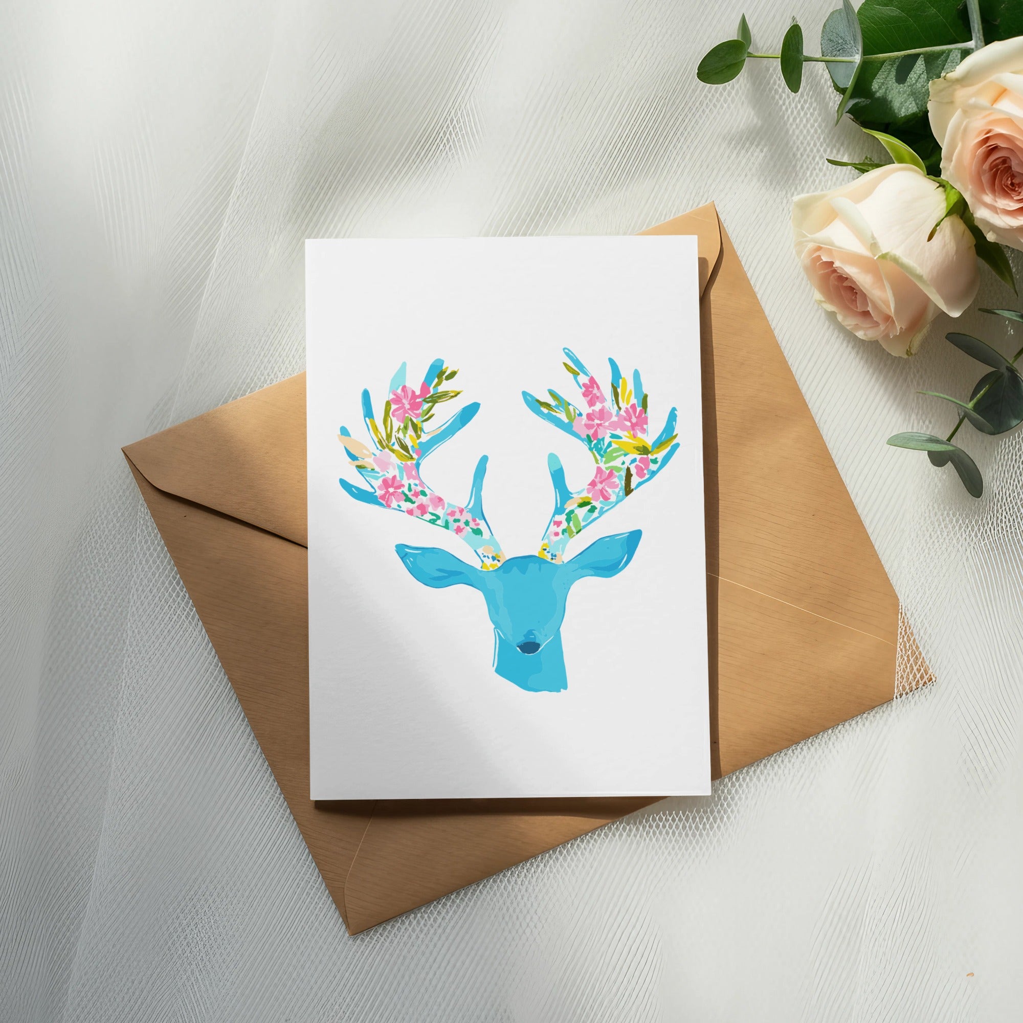 Card with a blue deer illustration and floral antlers on a brown envelope.