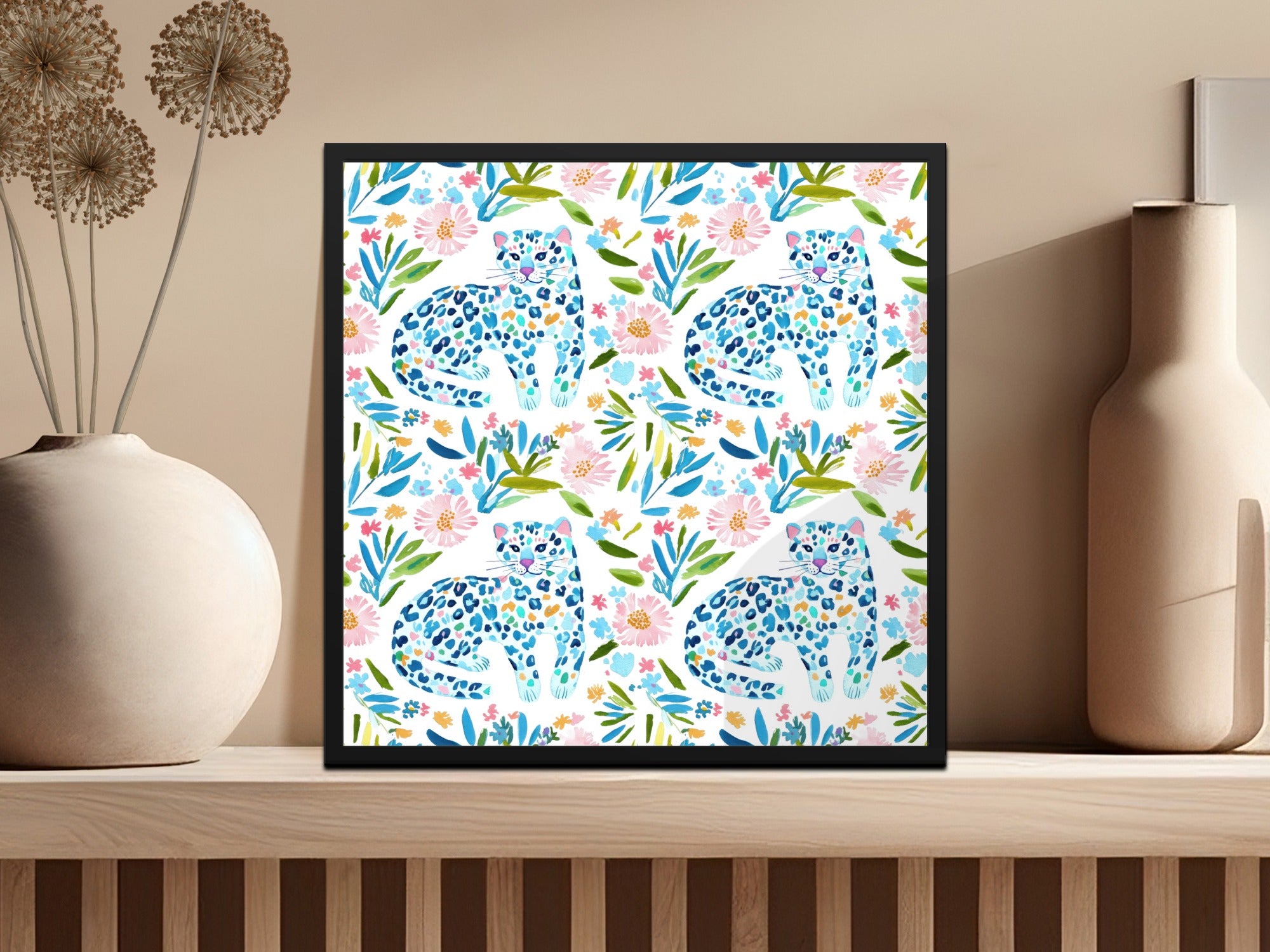 Framed artwork of repeating blue and white leopards among pink and green watercolor flowers.