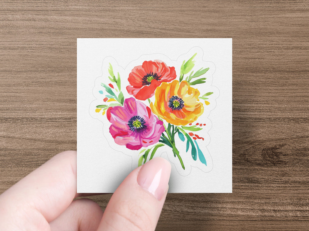 Watercolor bouquet of pink, orange, and red poppies held by a hand.