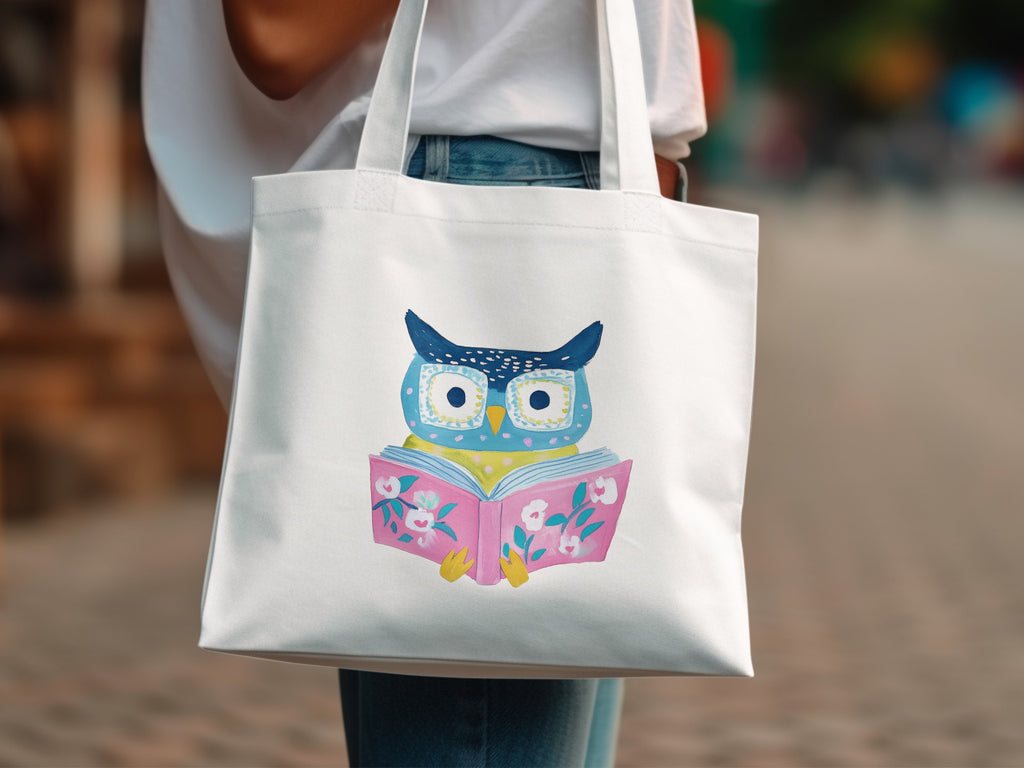 White tote bag with illustration of a blue owl reading a pink book.