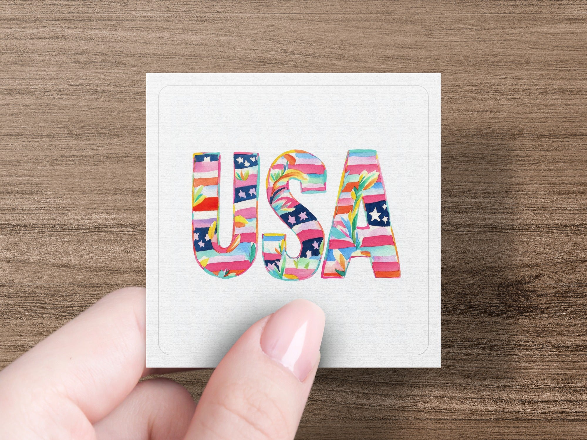 "USA" text in colorful floral pattern held by a hand.