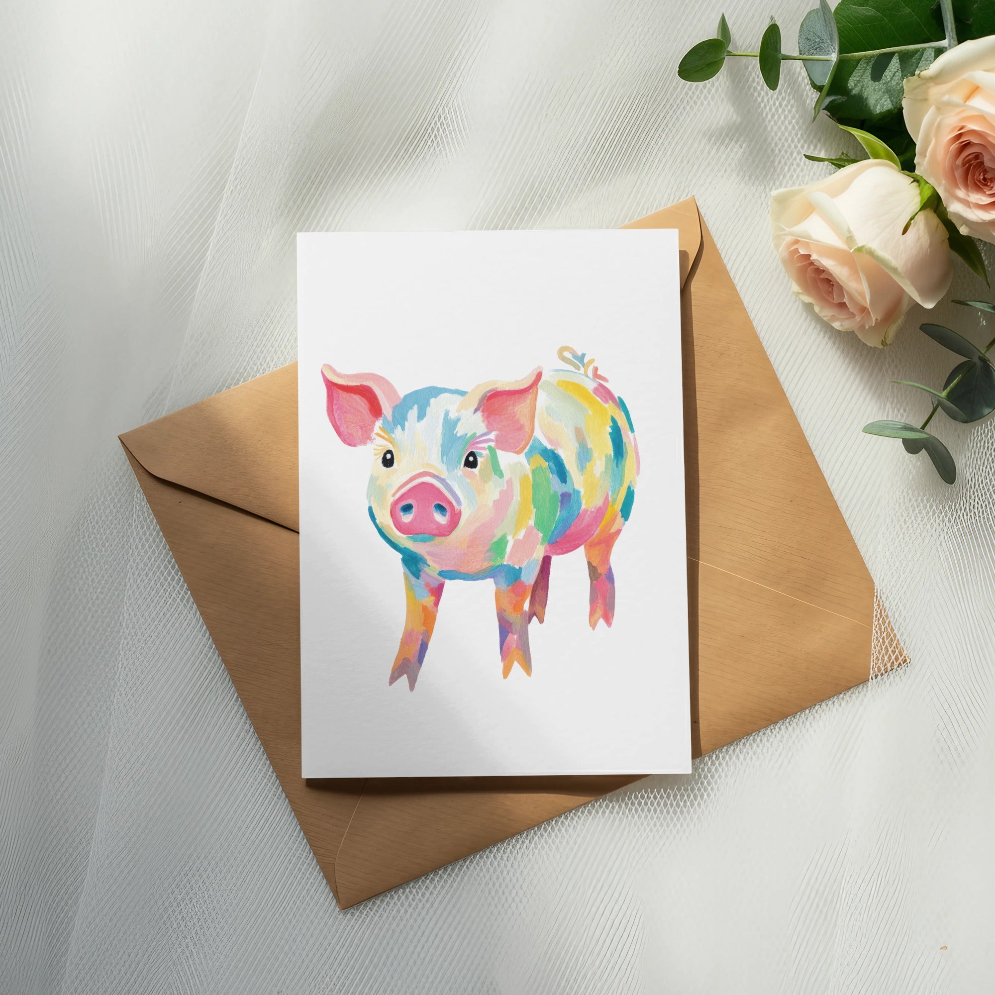 Watercolor illustration of a colorful pig on a card, resting on an envelope.