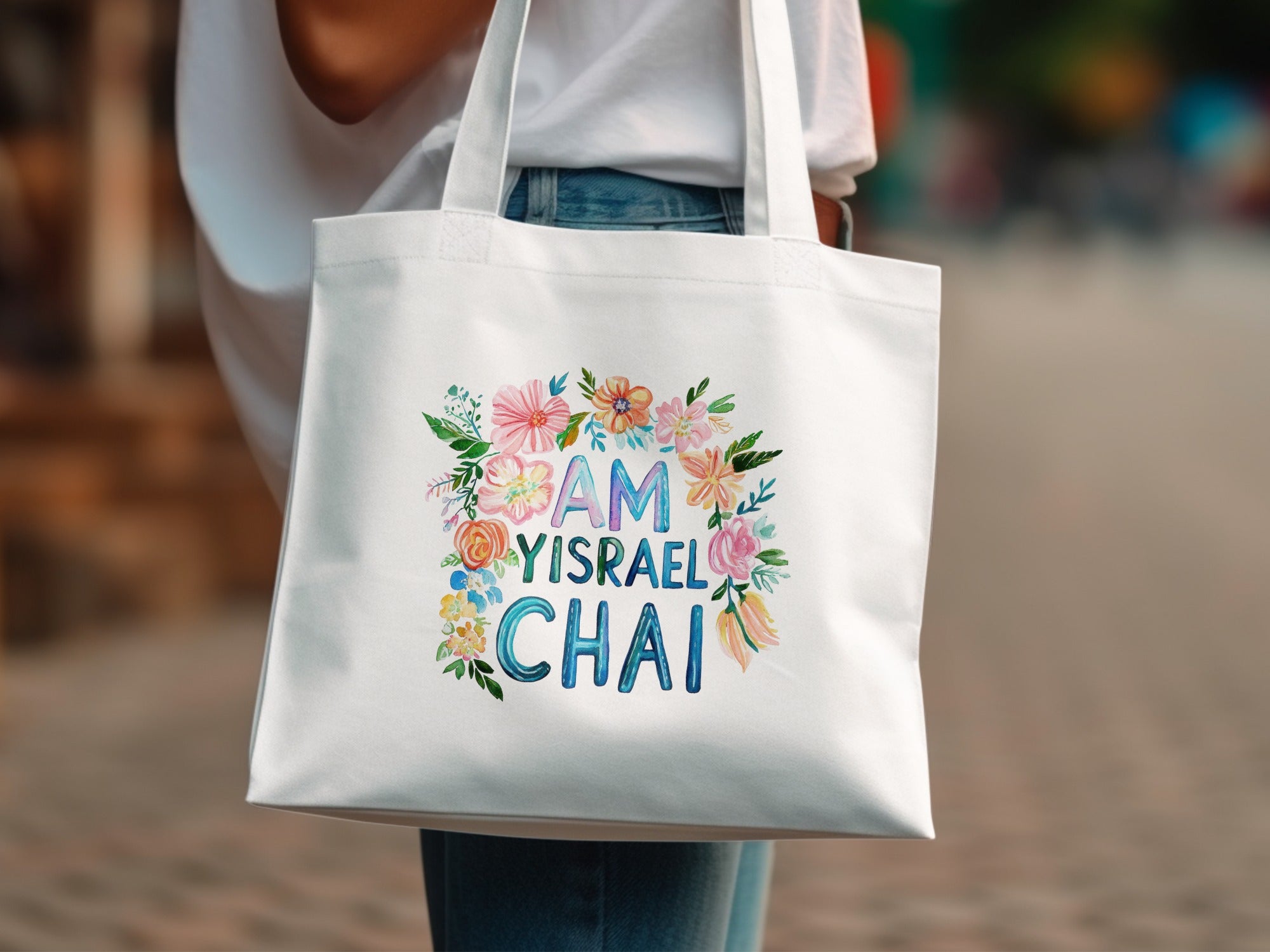 White tote bag with "Am Yisrael Chai" text surrounded by flowers.
