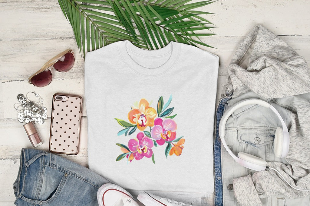 White t-shirt with colorful orchid floral graphic, flat lay with clothing and accessories.