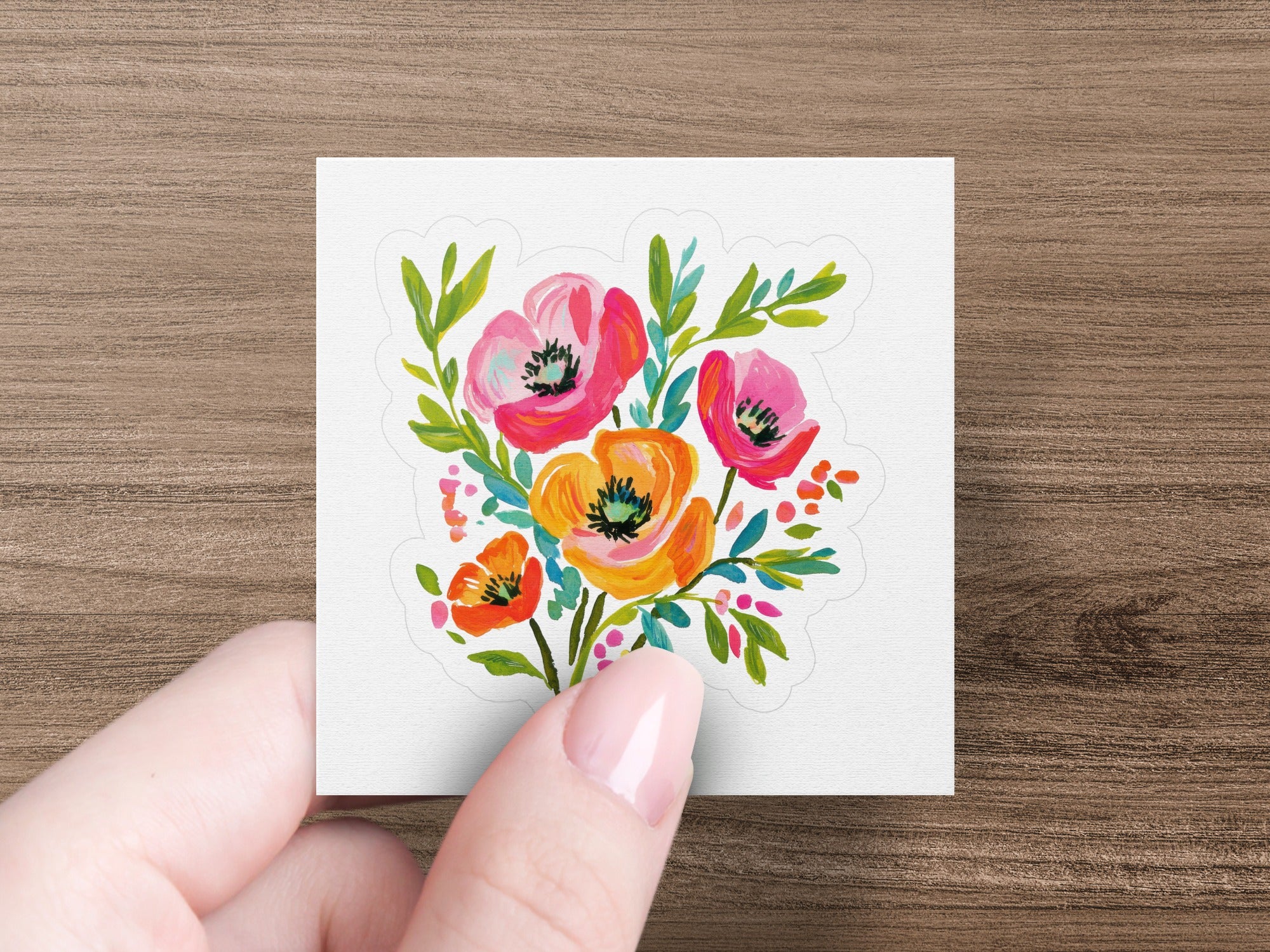 Watercolor bouquet of poppies in pink, orange, and red with green leaves.