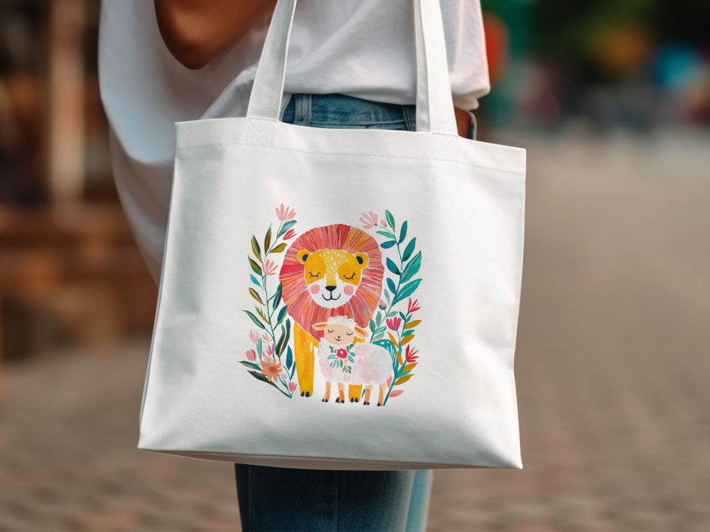 White tote bag featuring a watercolor illustration of a lion and lamb surrounded by flowers.