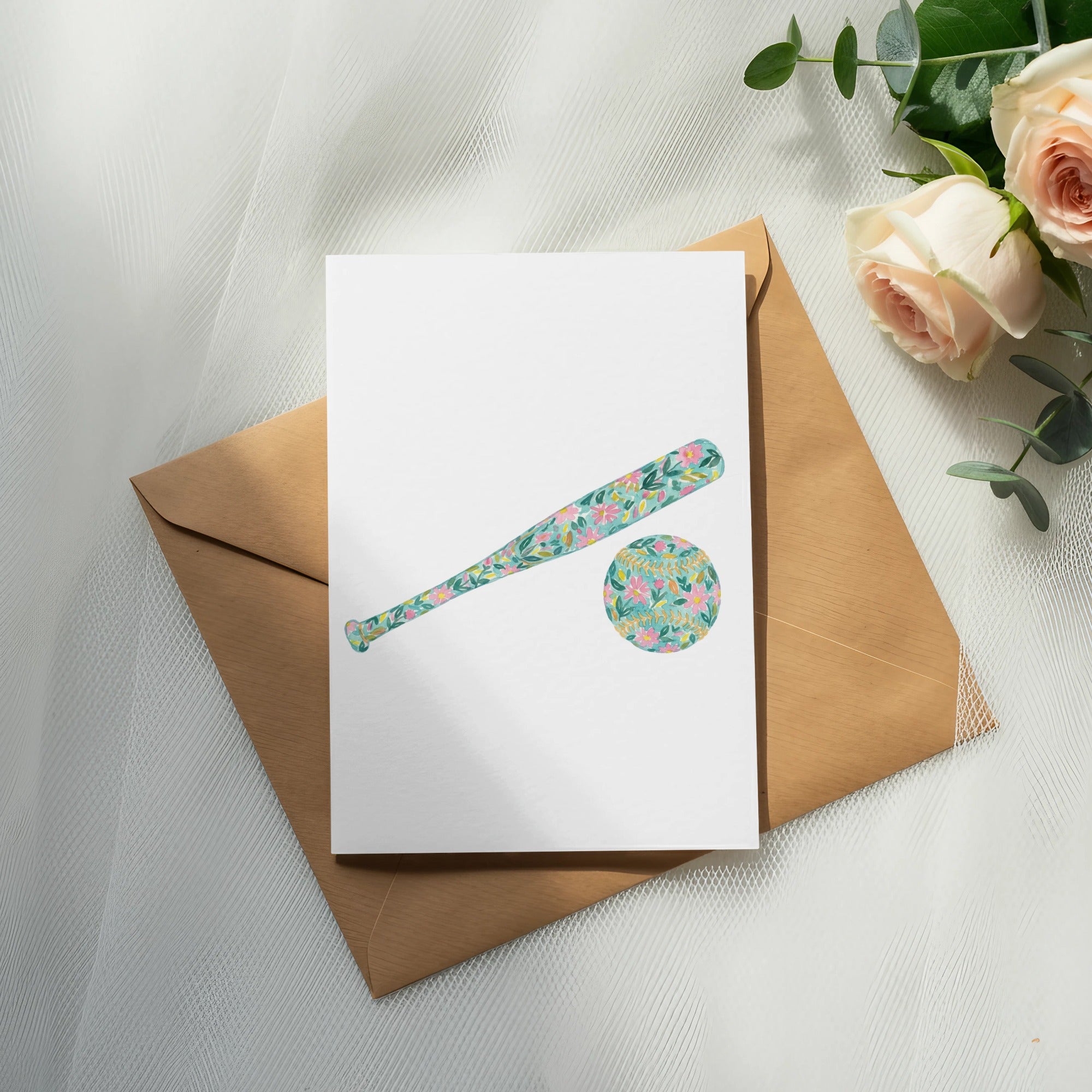 Card with floral baseball bat and ball on envelope next to roses.
