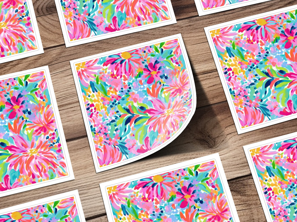 Colorful floral pattern on multiple square cards with white borders on a wooden surface.