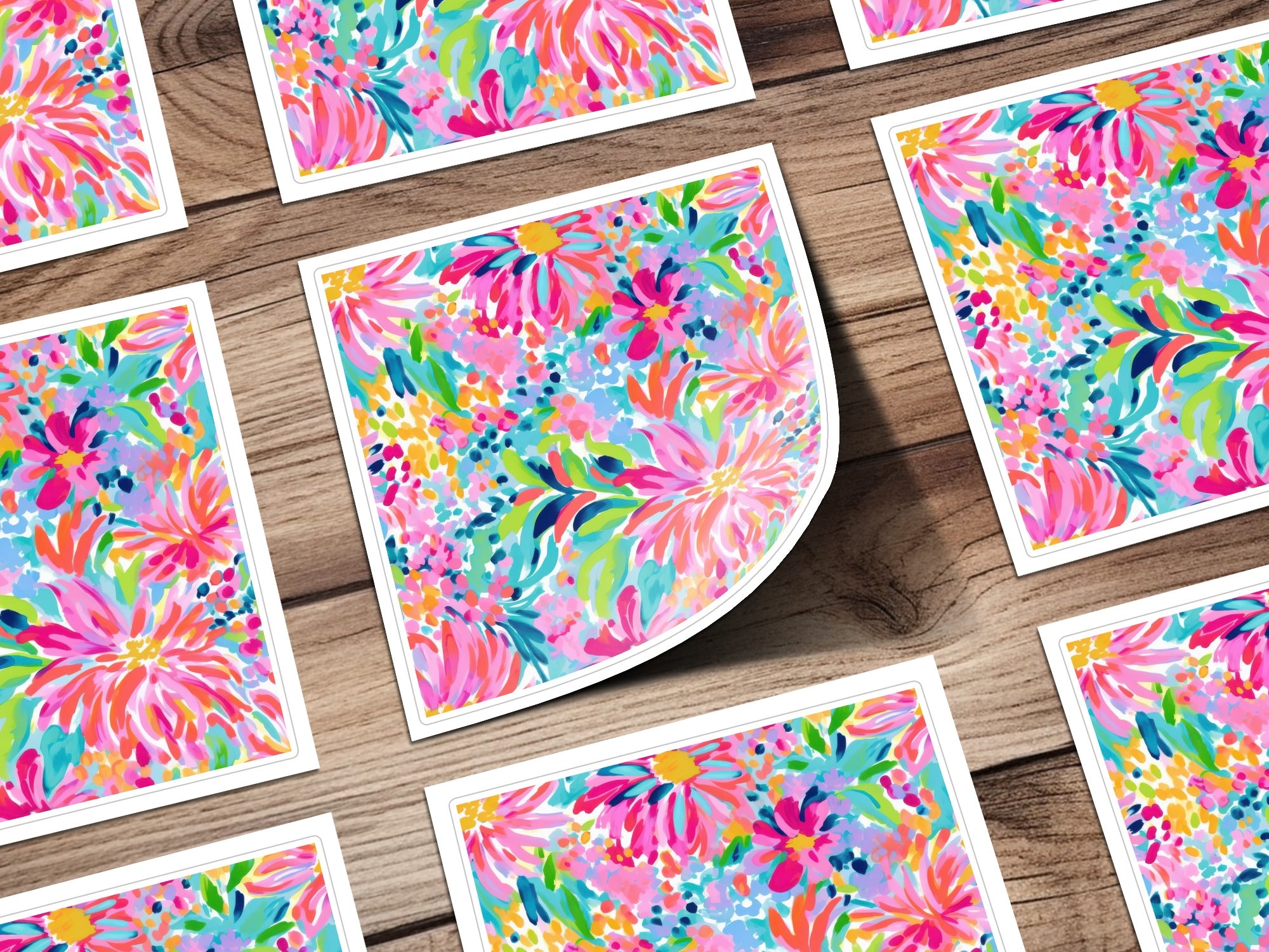 Colorful floral pattern on multiple square cards with white borders on a wooden surface.