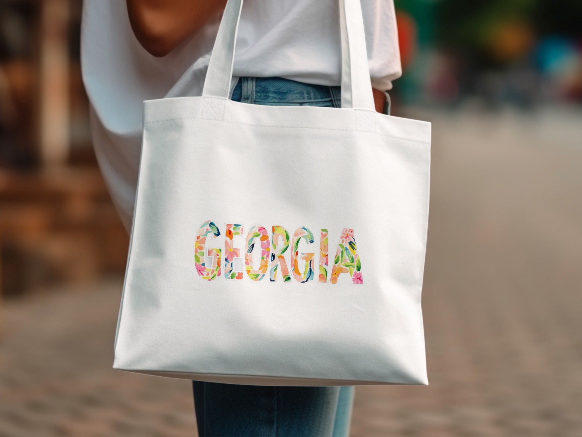 White tote bag with "GEORGIA" in colorful floral letters.
