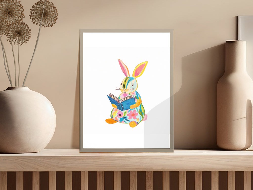 Watercolor illustration of a colorful bunny reading a book with floral designs.