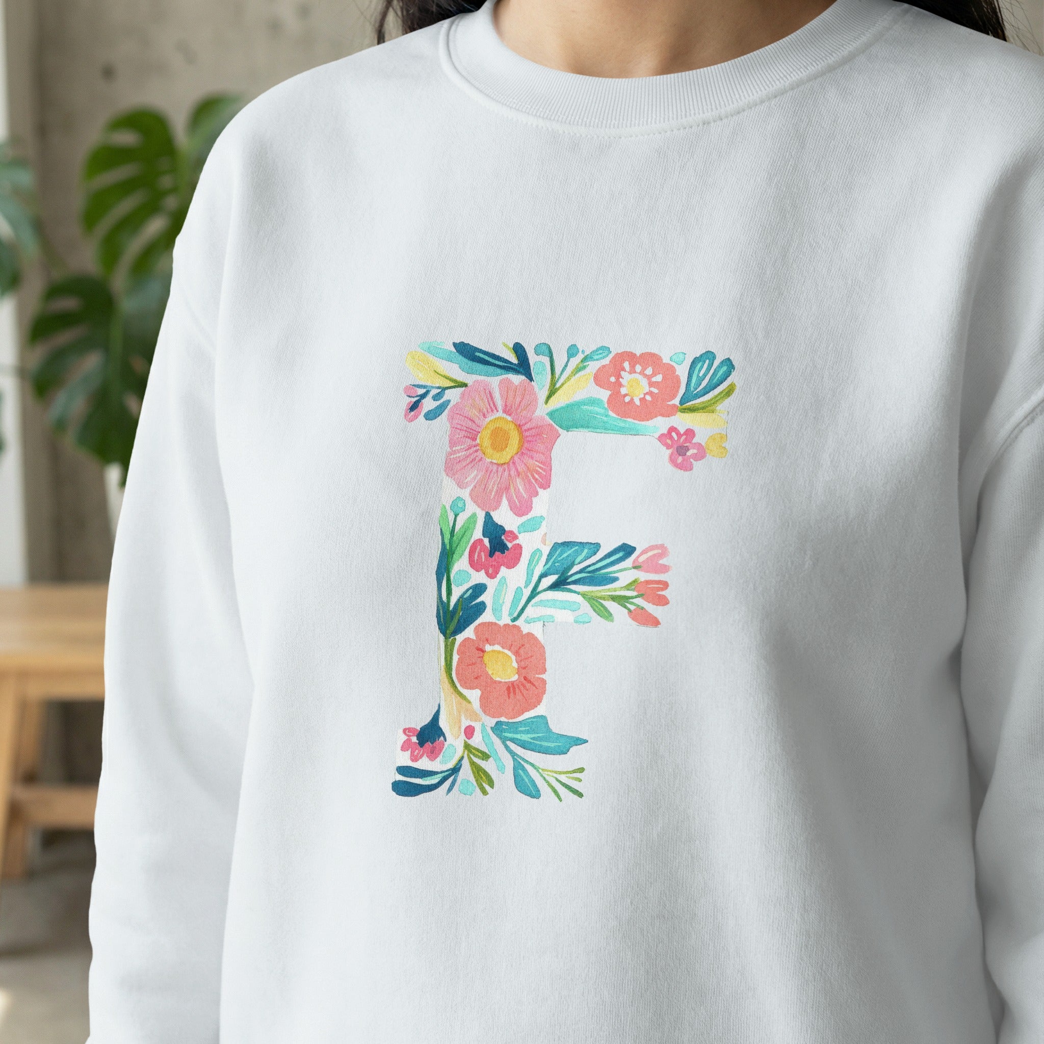 White sweatshirt with embroidered floral letter F design.