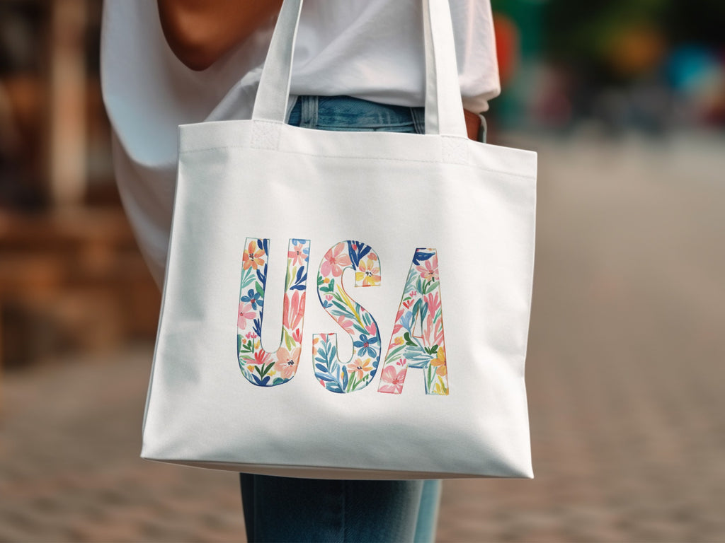 White canvas tote bag with "USA" in colorful floral letters.