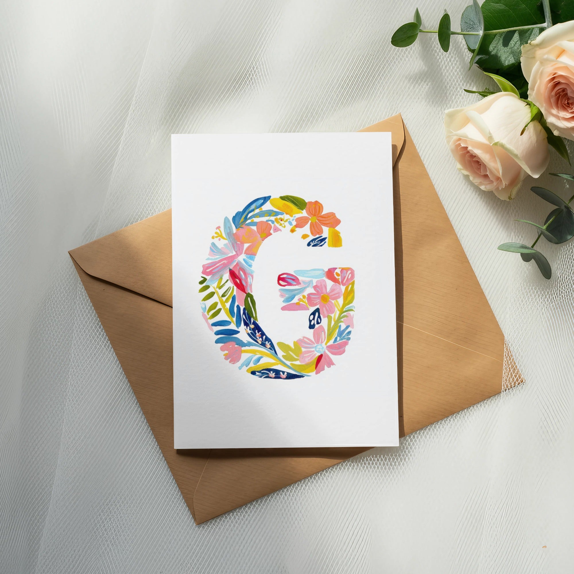 Card with a floral letter G on a brown envelope.