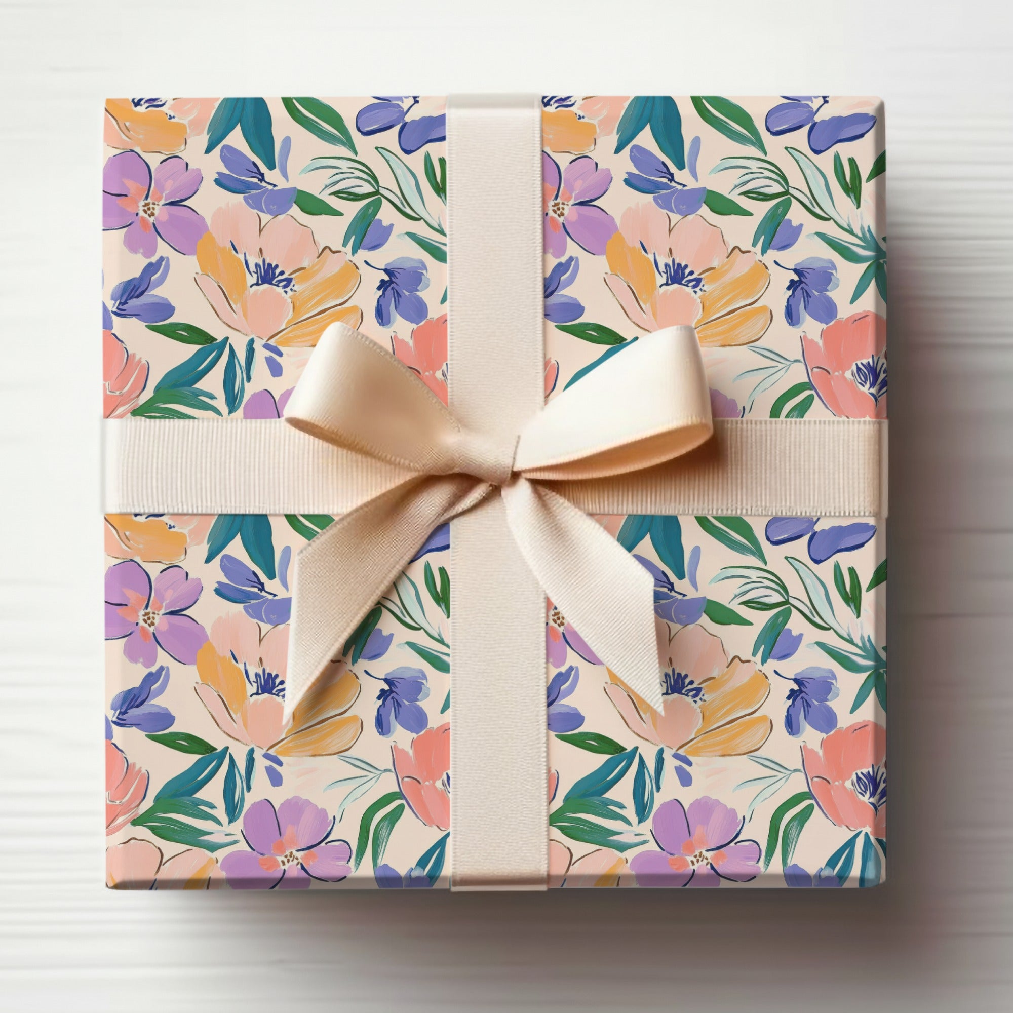 Gift box with floral pattern and light beige ribbon bow.