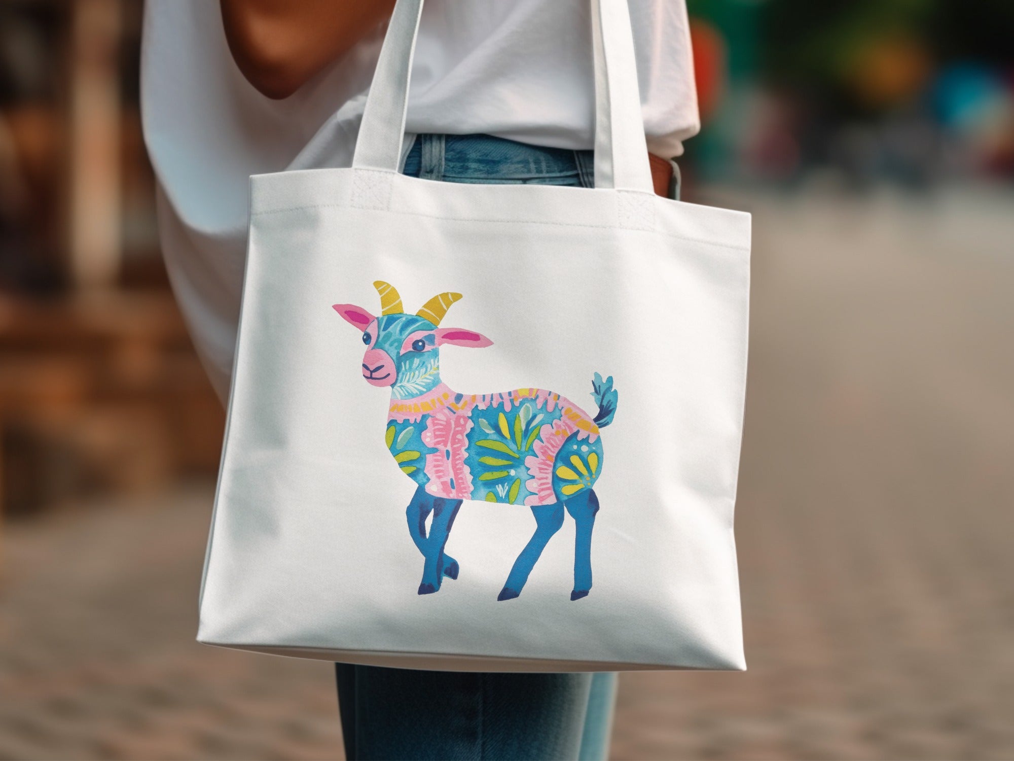 White tote bag with a colorful illustrated goat.