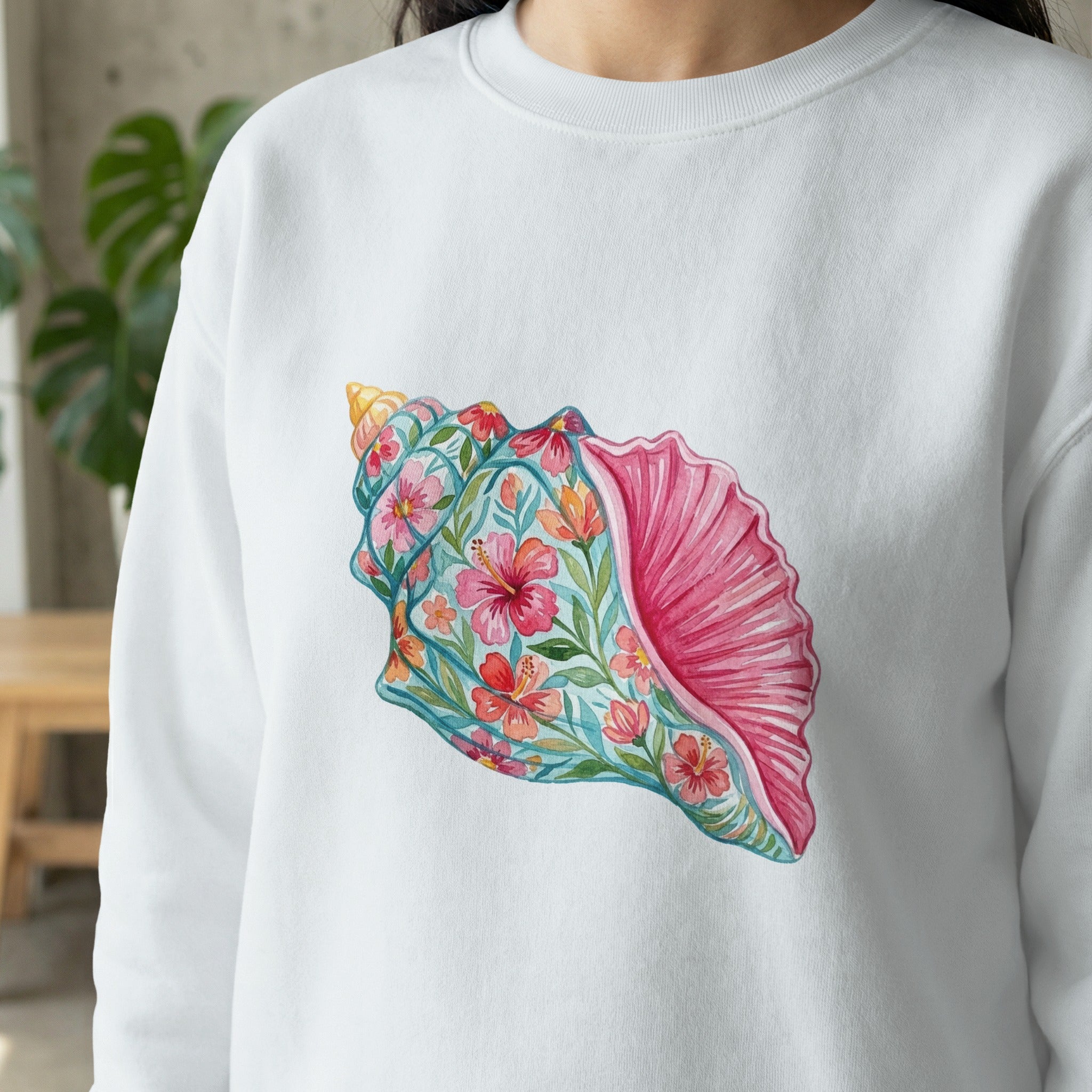 White sweatshirt with a vibrant seashell floral design.