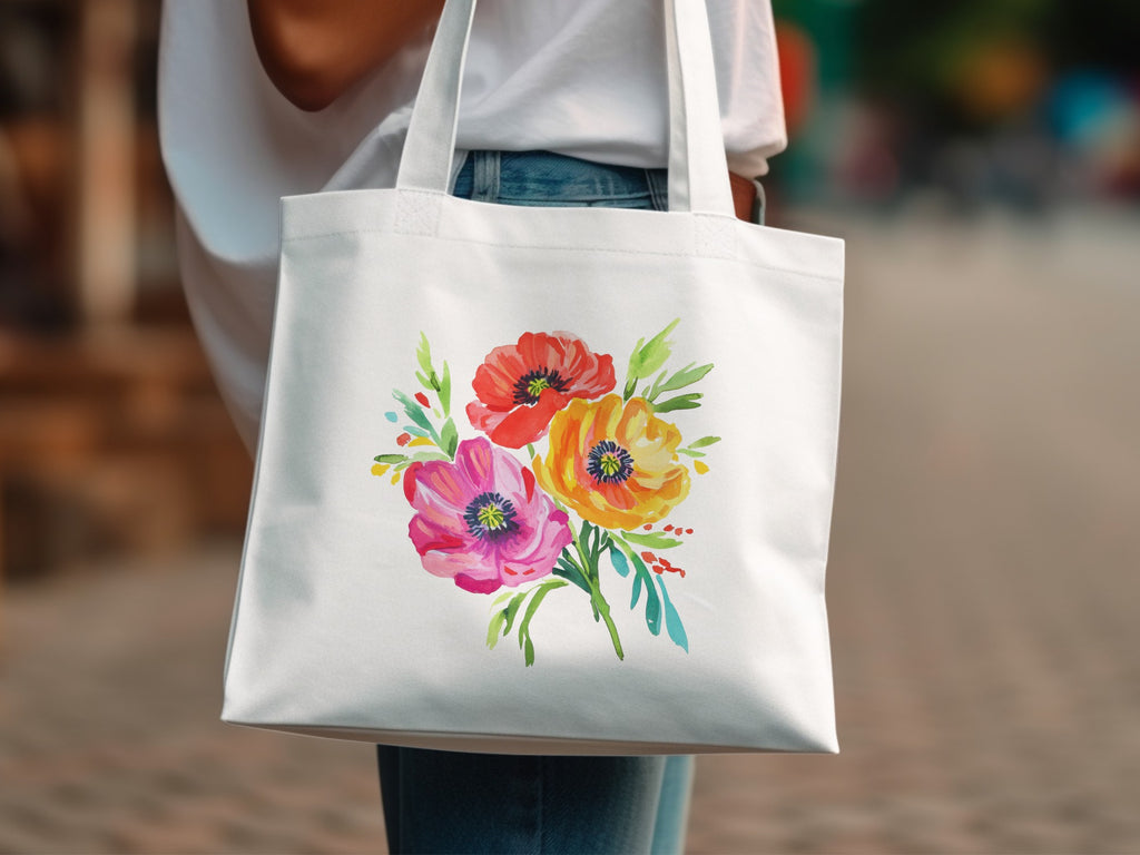 White canvas tote bag with a watercolor floral design of red, pink, and yellow poppies.