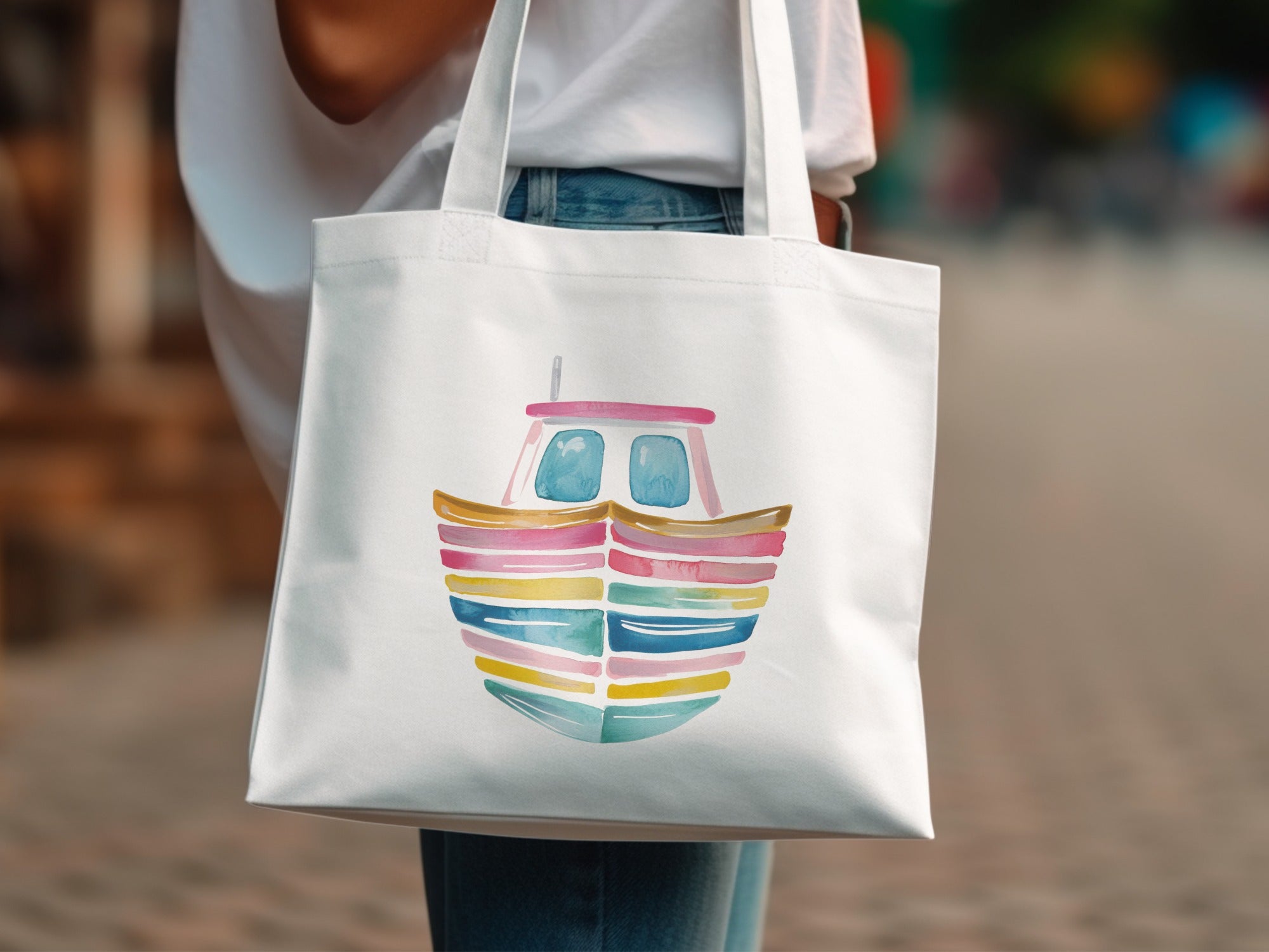 White tote bag with a watercolor painting of a colorful striped boat.