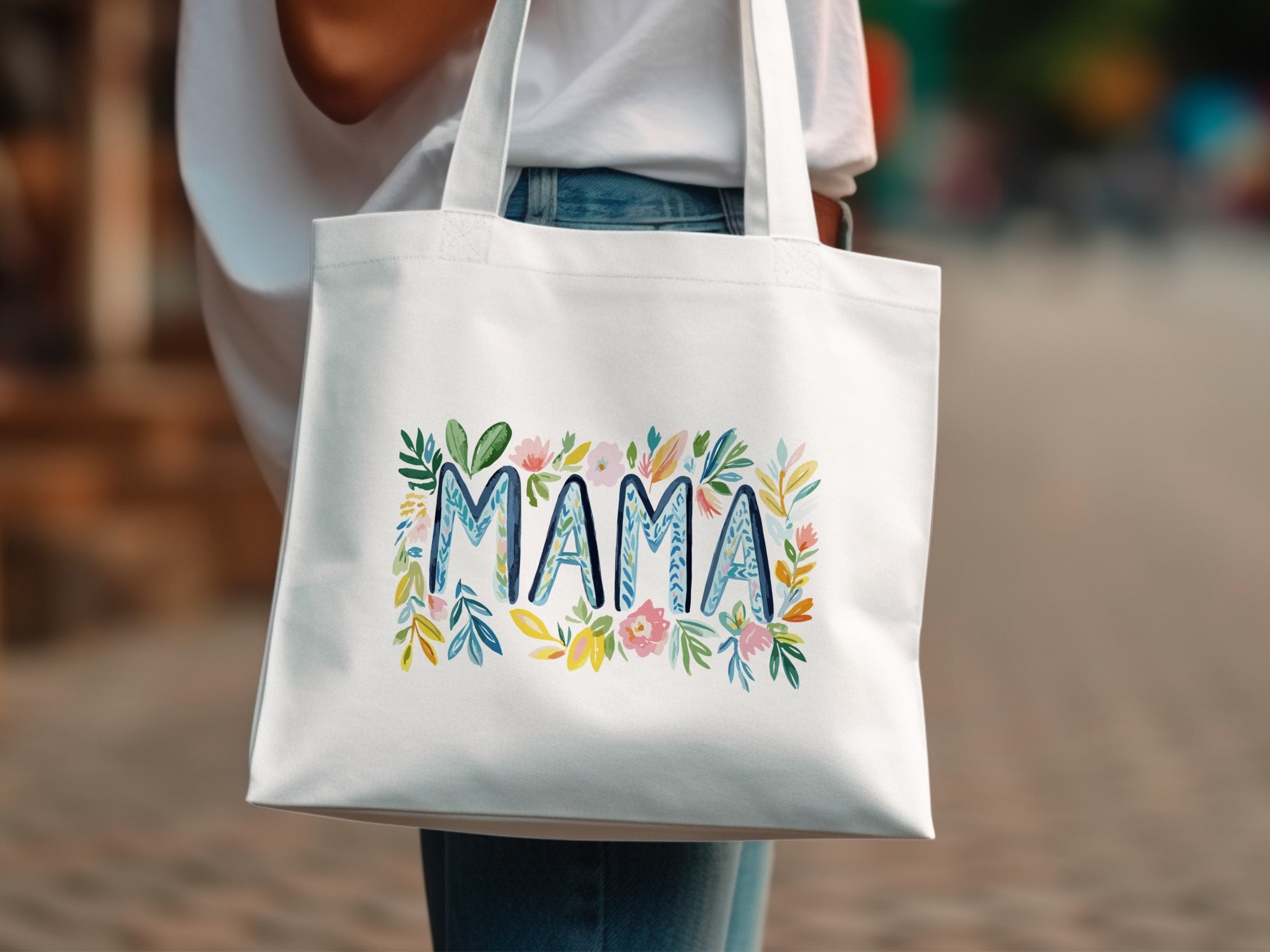 White tote bag with floral "MAMA" lettering.