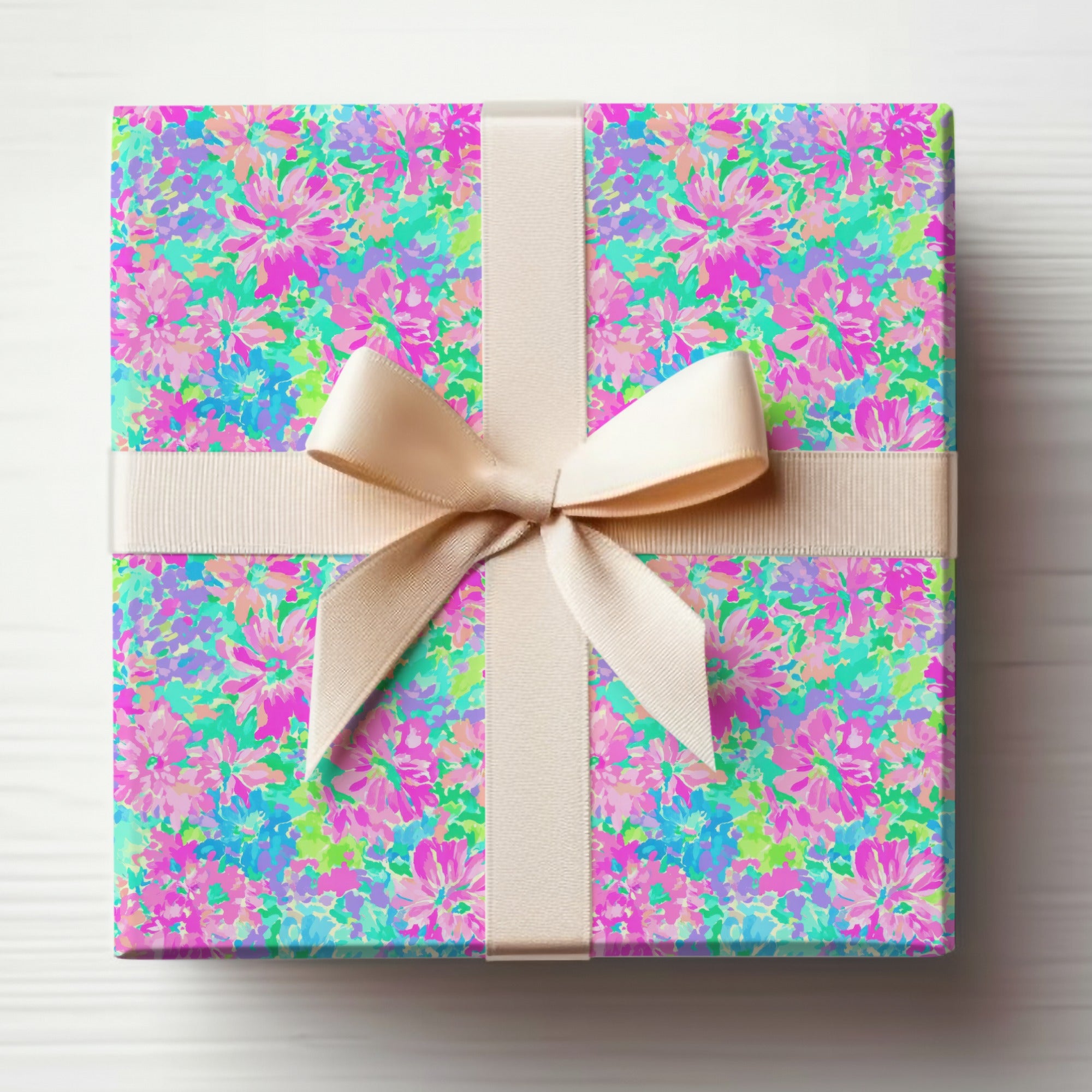 Gift-wrapped box with colorful floral pattern and beige ribbon bow.