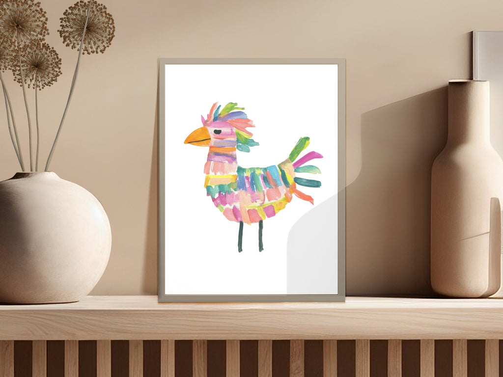 Colorful abstract bird artwork in a simple white frame on a shelf.