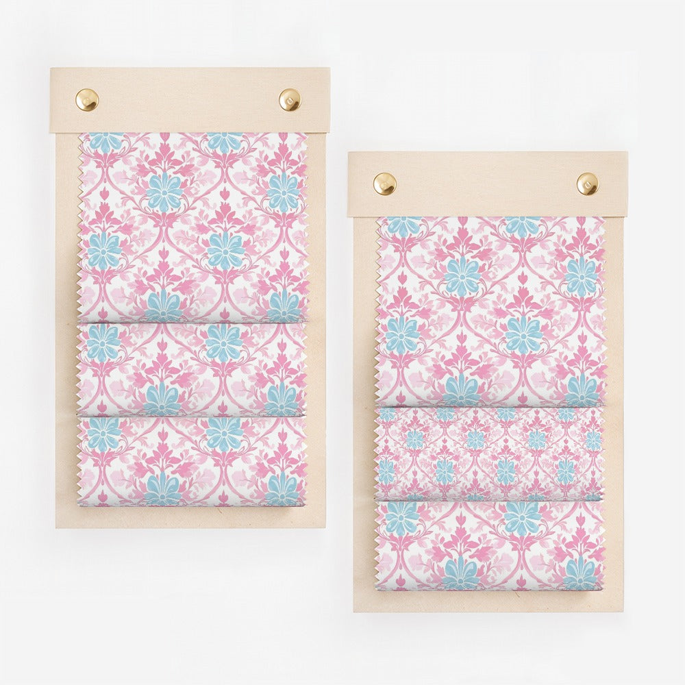 Two fabric swatches with pink and blue floral pattern on wooden boards.