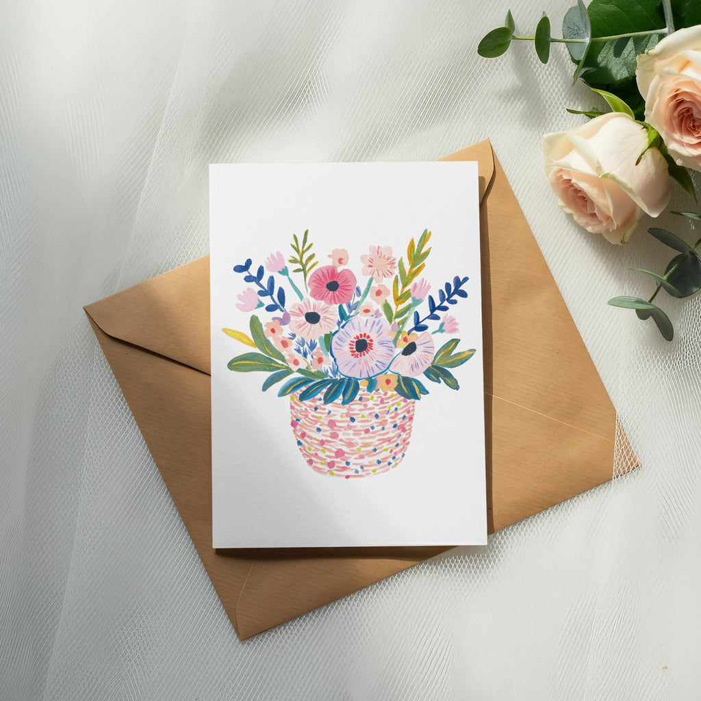 Card with a colorful basket of flowers resting on an envelope.