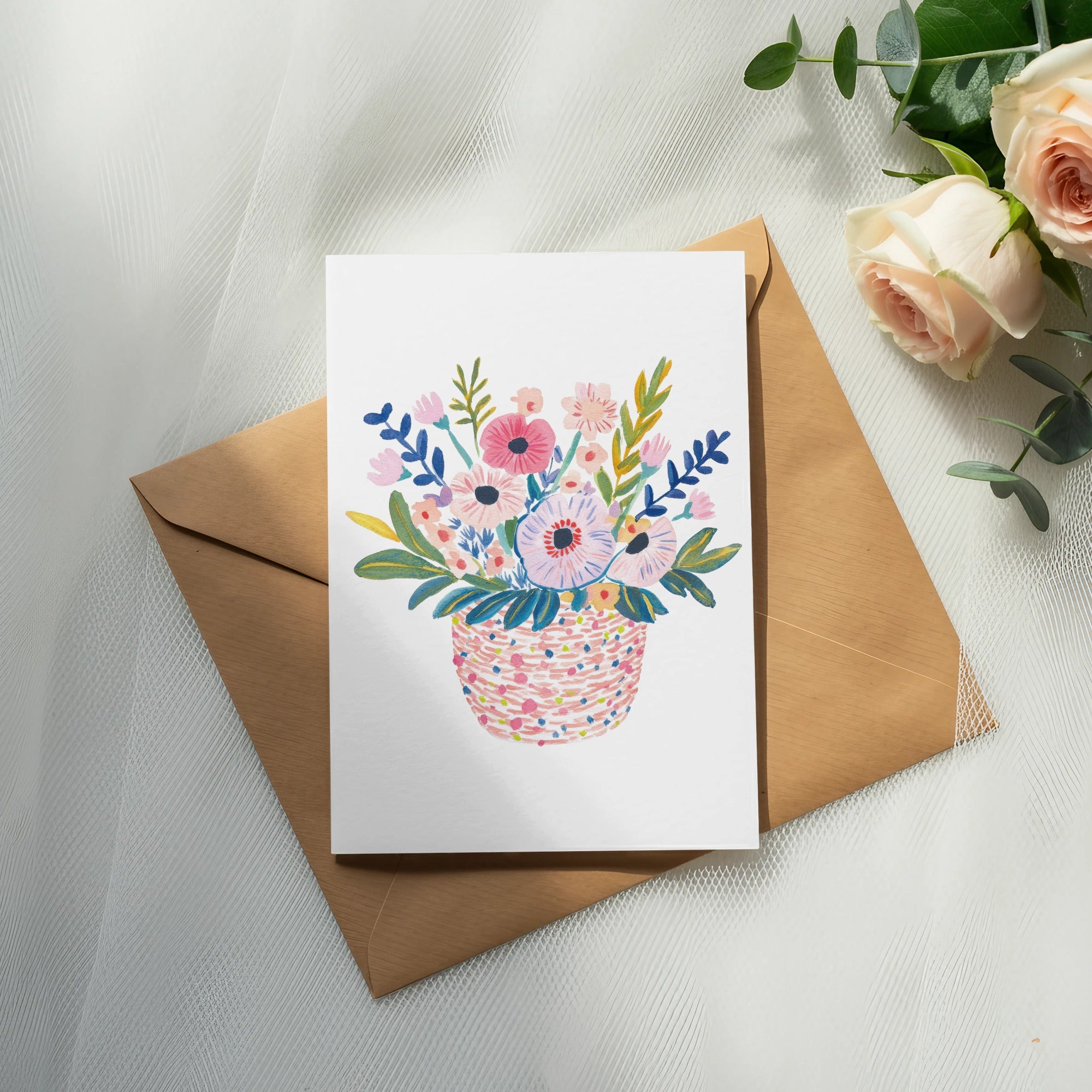 Card with a colorful basket of flowers resting on an envelope.