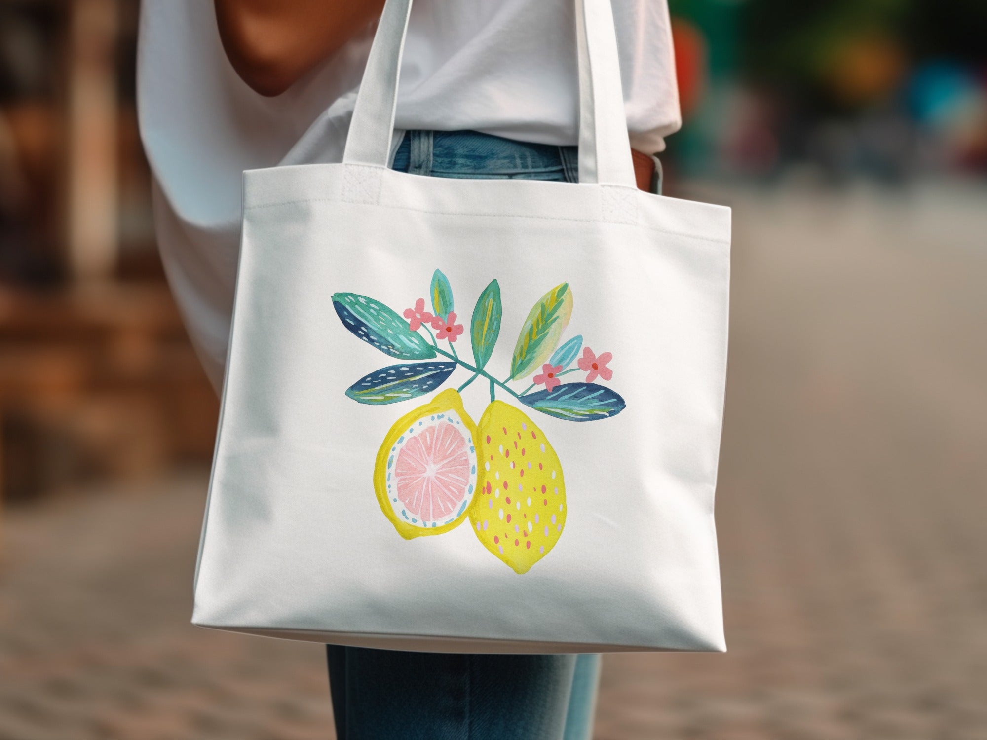White tote bag with a watercolor illustration of lemons and pink flowers.