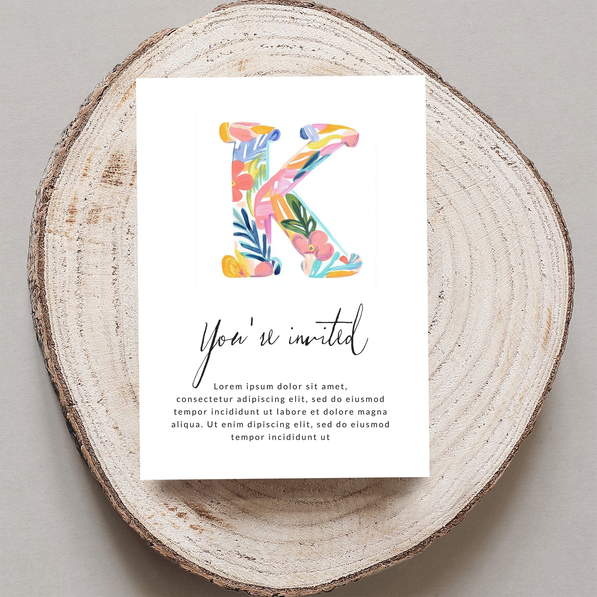 Invitation card with large colorful letter K and "You're invited" text.