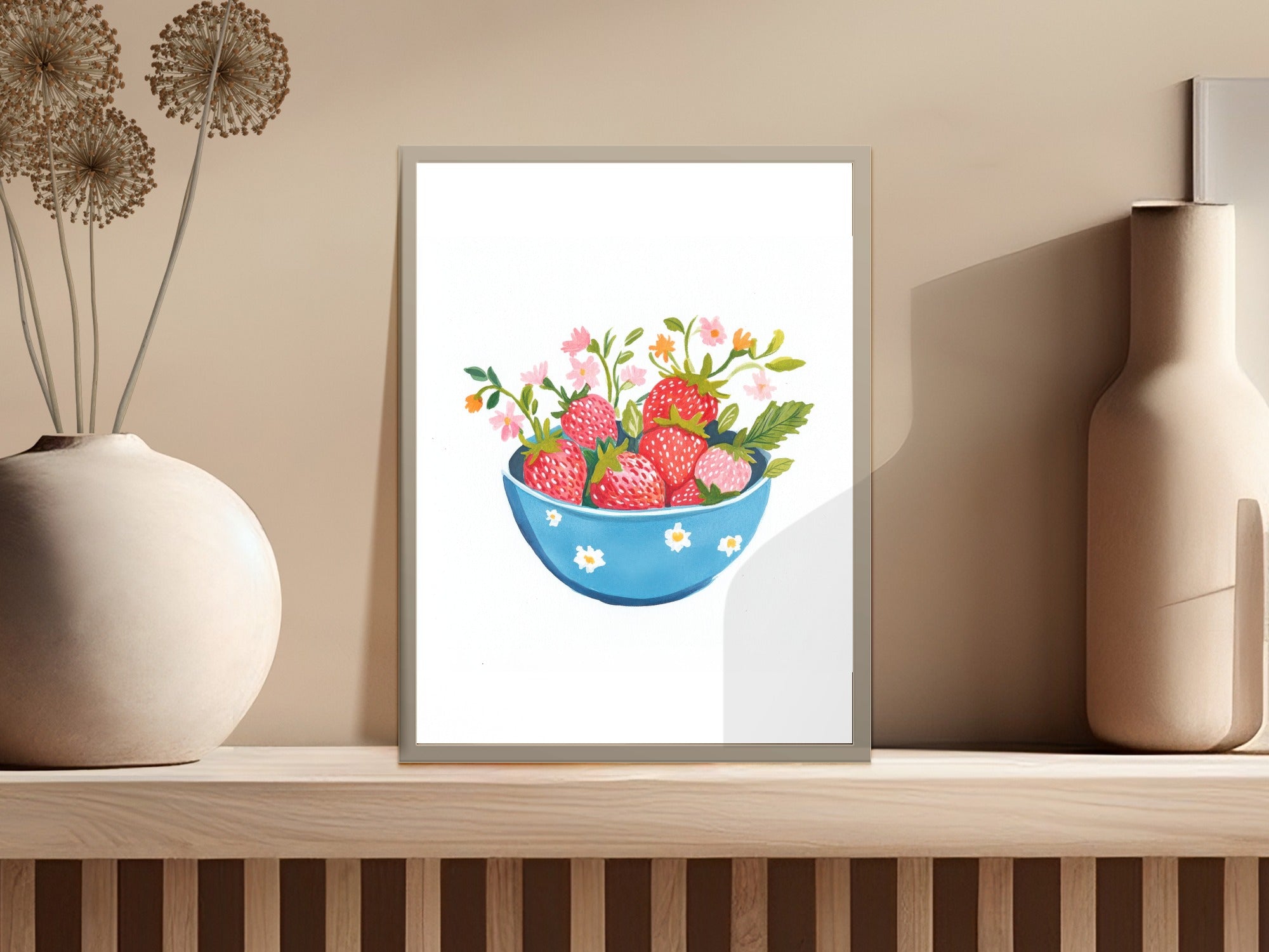 Blue bowl overflowing with strawberries and small pink flowers.