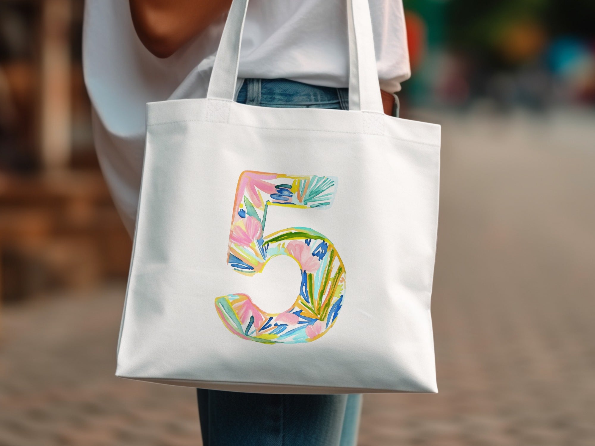 White tote bag with a colorful watercolor number 5 design.