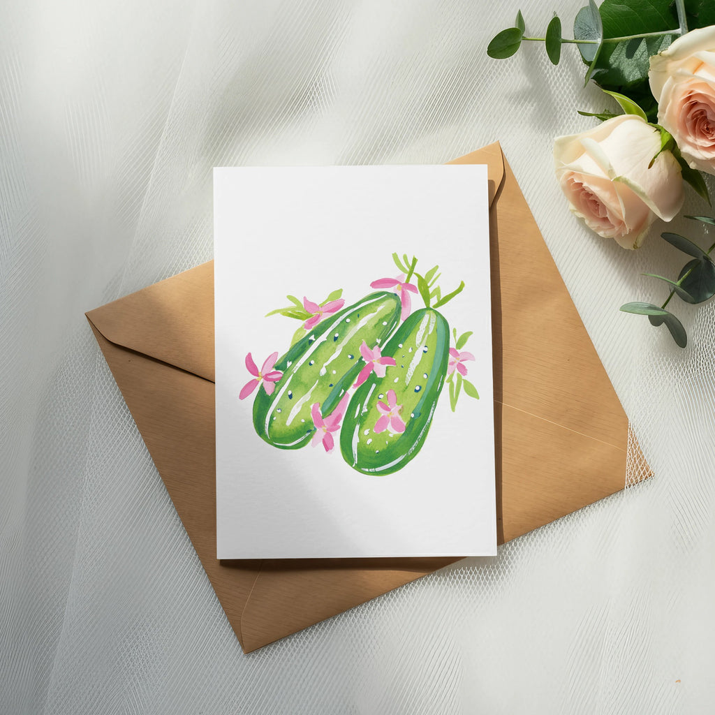 Watercolor illustration of two smiling cucumbers on a card, with roses and eucalyptus.