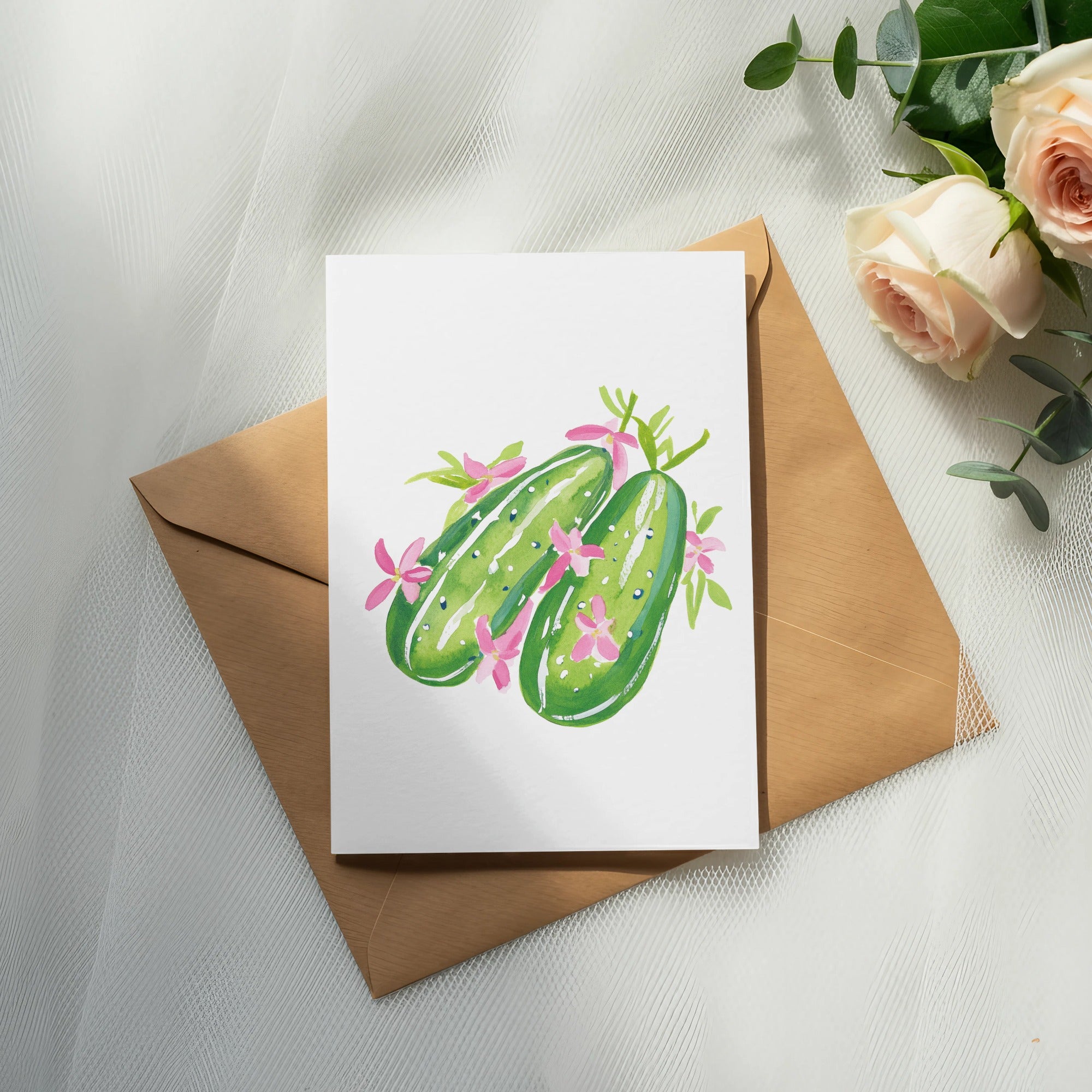 Watercolor illustration of two smiling cucumbers on a card, with roses and eucalyptus.