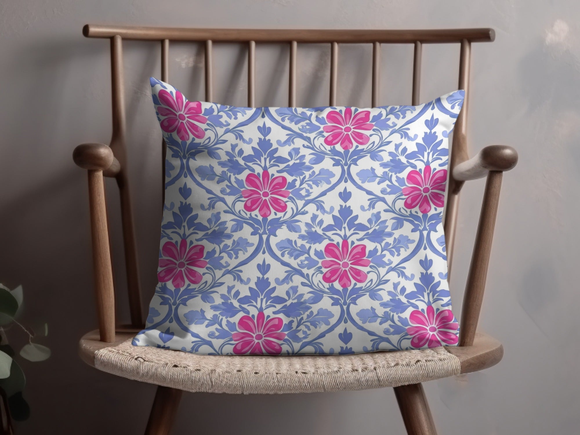 Throw pillow with a blue floral pattern on a wooden chair.