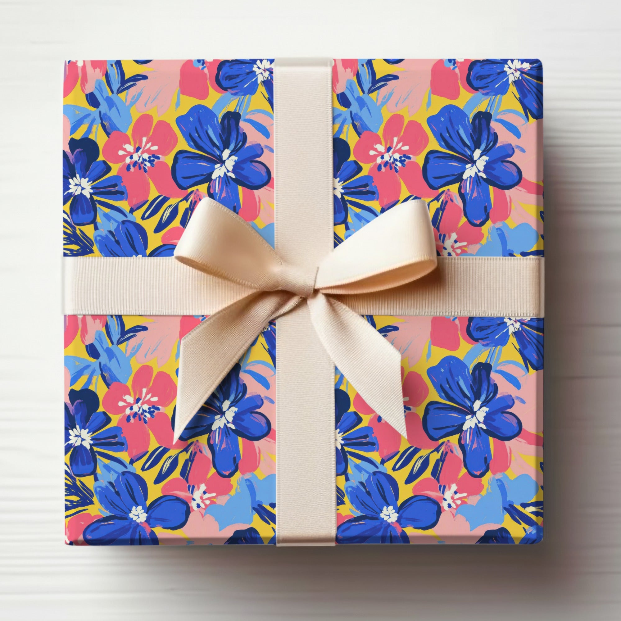Gift-wrapped box with blue, pink, and yellow floral pattern and cream ribbon.