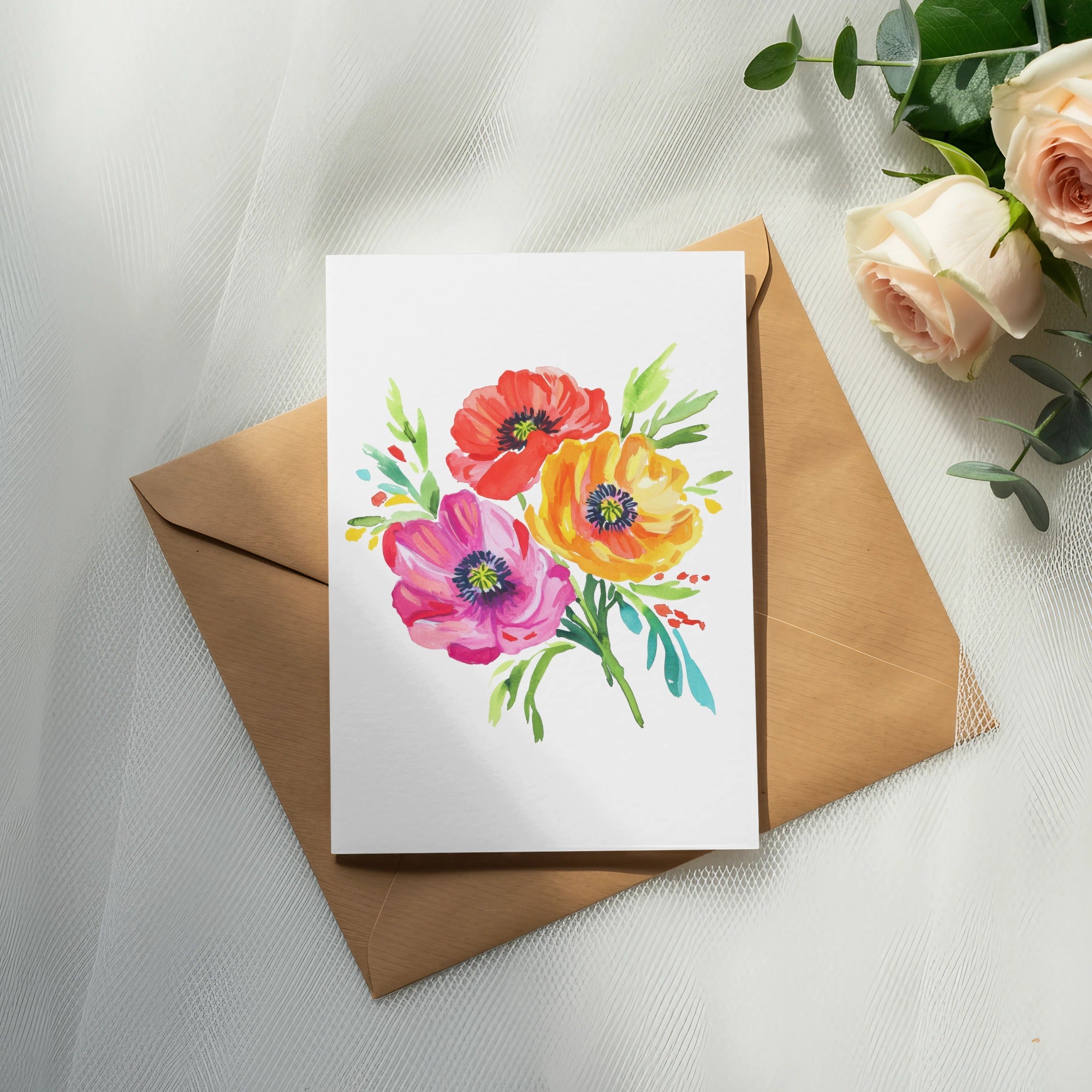 Watercolor floral bouquet on a blank card atop a brown envelope.